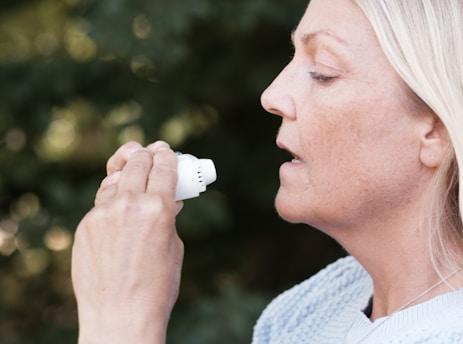 A woman using an electric toothbrush to brush her teeth