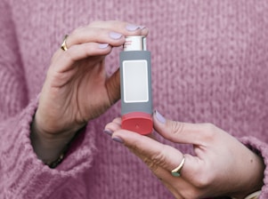 A woman holding a small electronic device in her hands