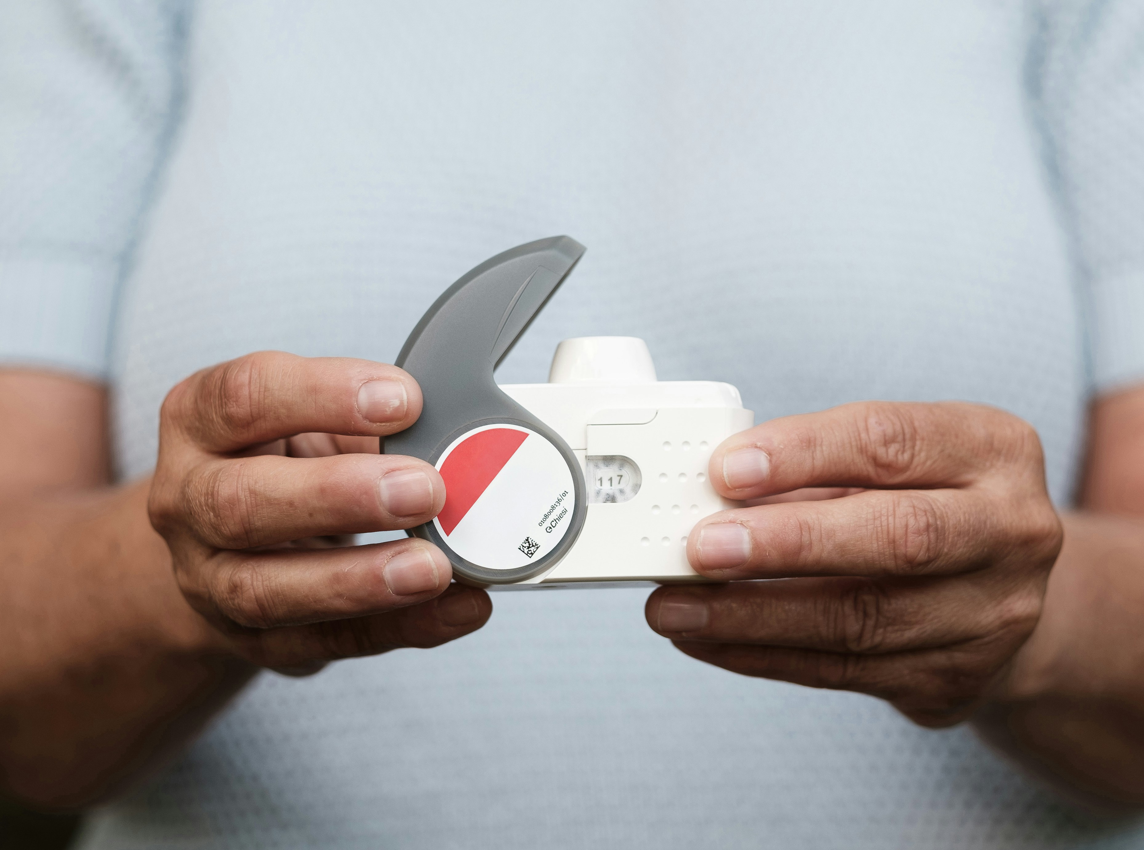 A person holding a small device in their hands