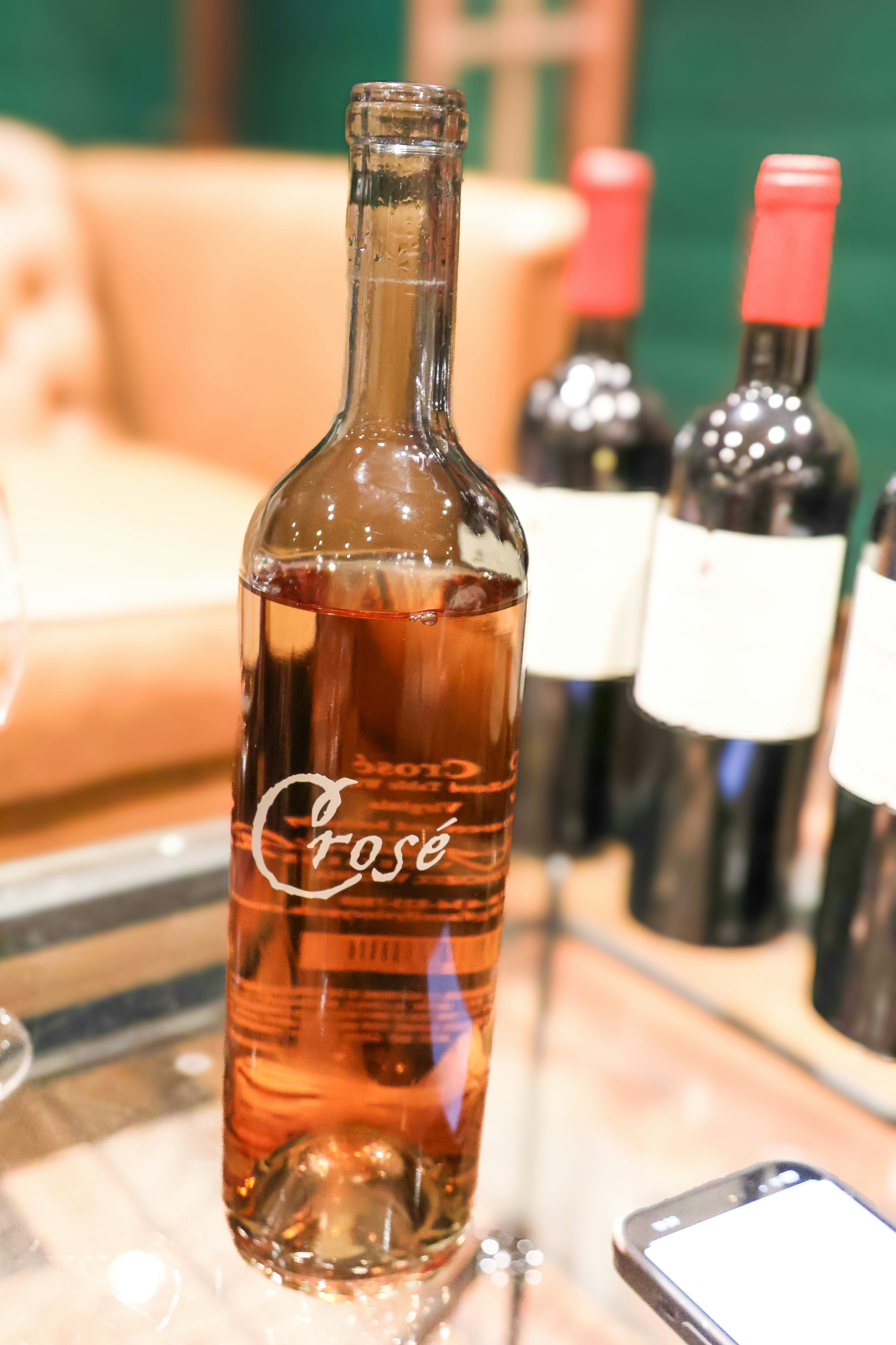 A bottle of wine sitting on top of a glass table