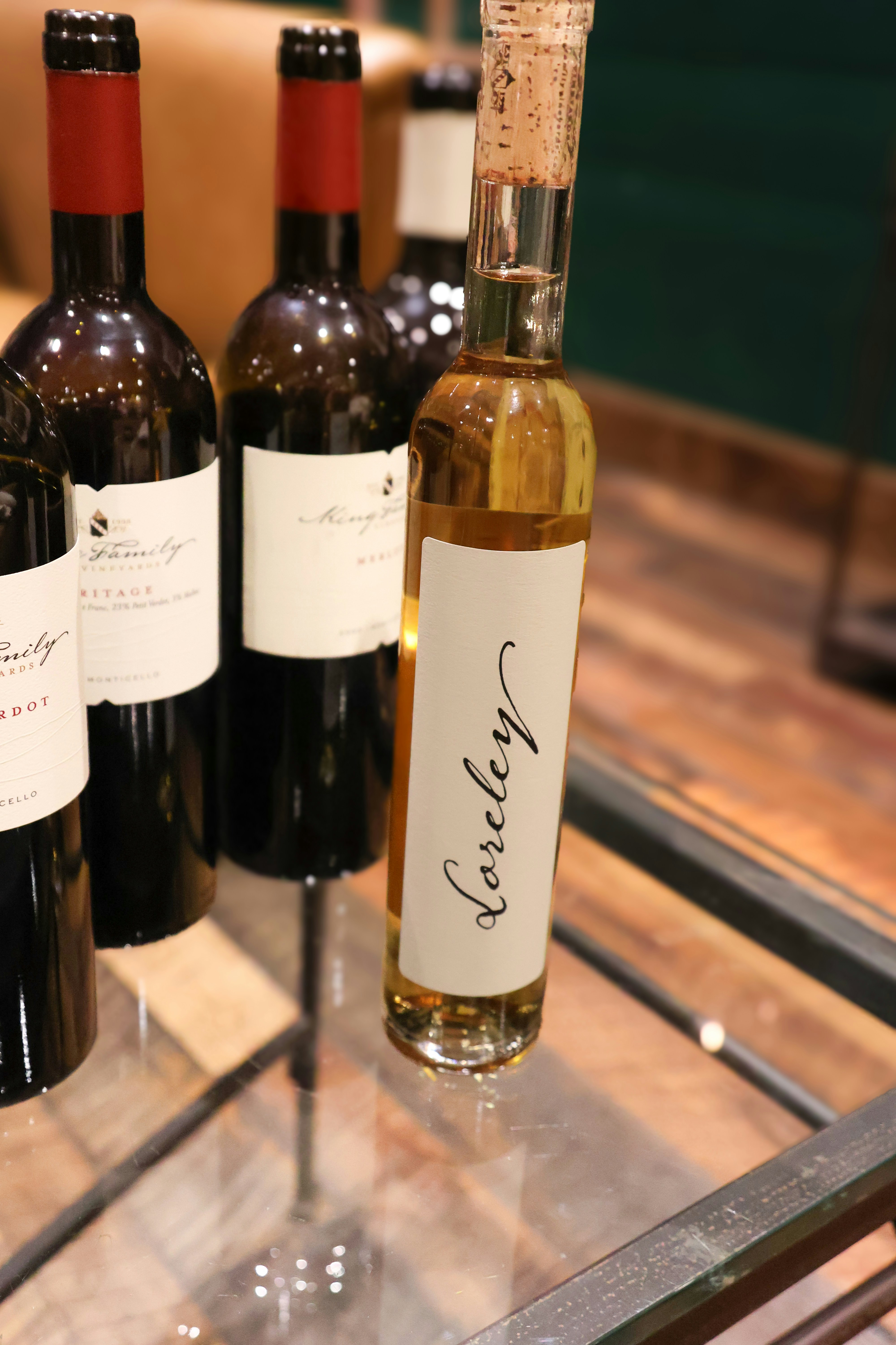 Three bottles of wine sitting on a glass table
