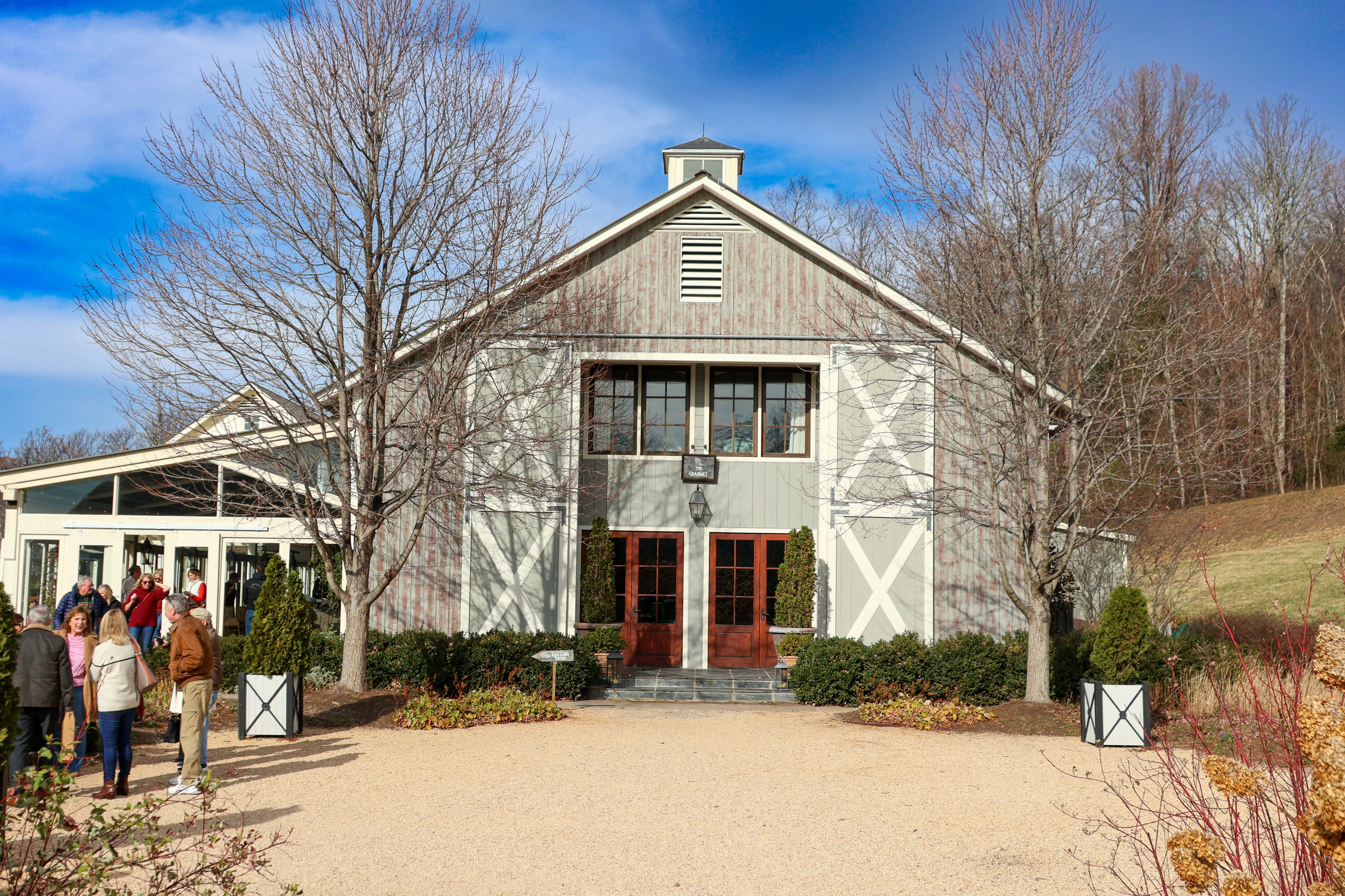 A group of people standing in front of a barn