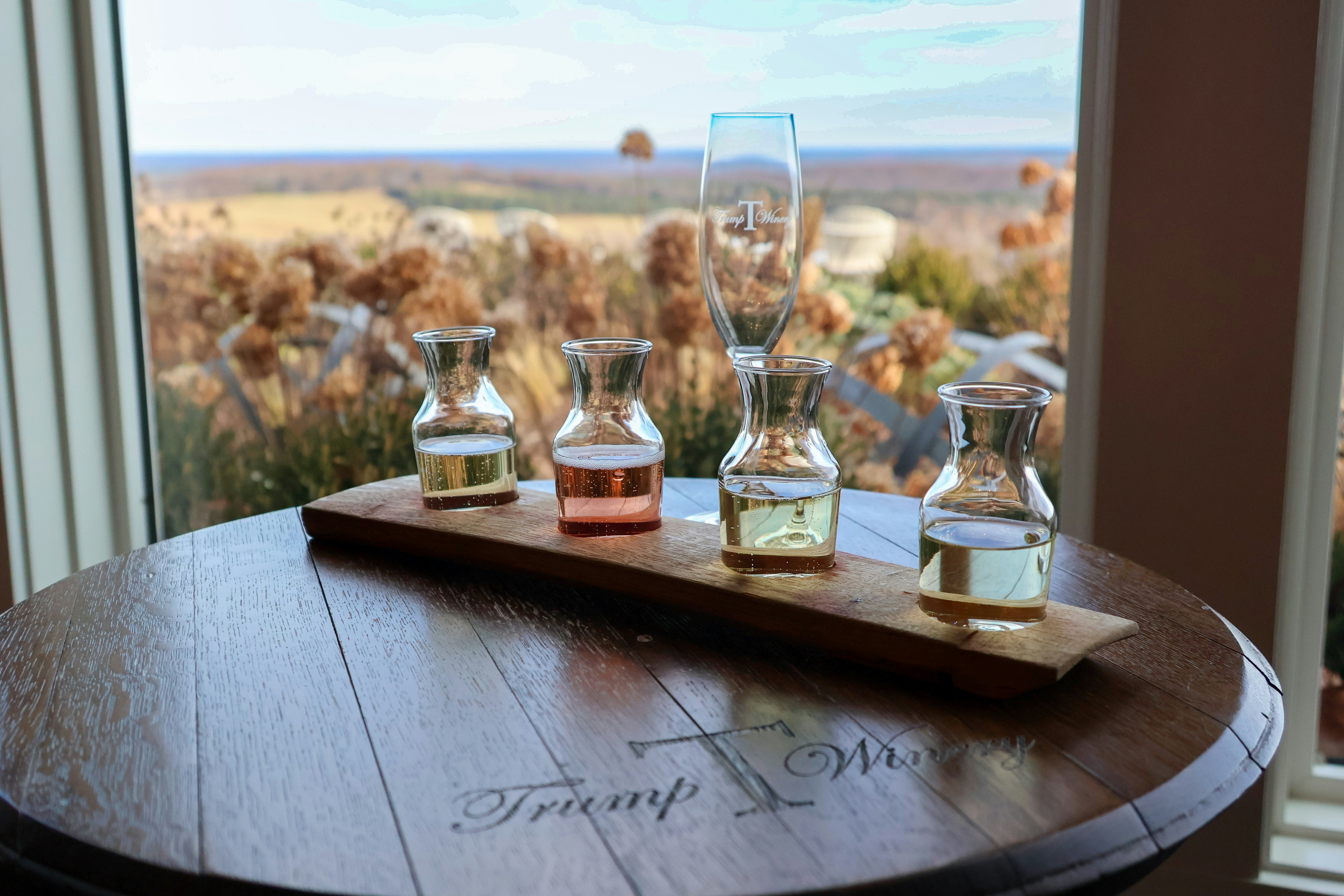 A wooden table topped with glasses filled with liquid