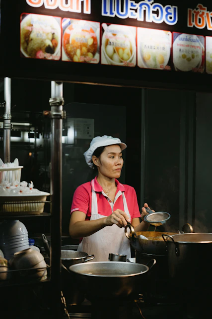 A woman is cooking in a restaurant kitchen