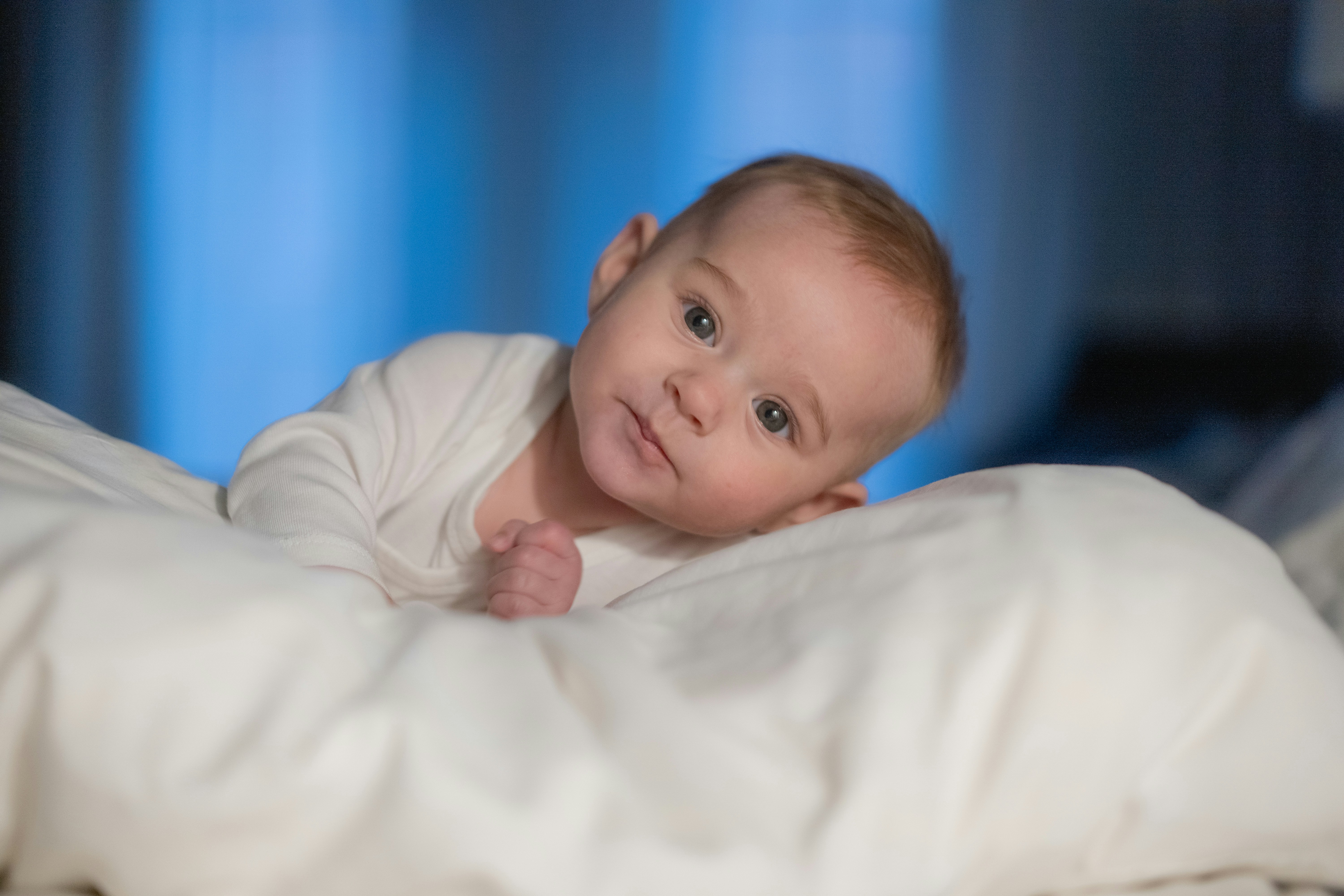 A baby is laying in a white blanket