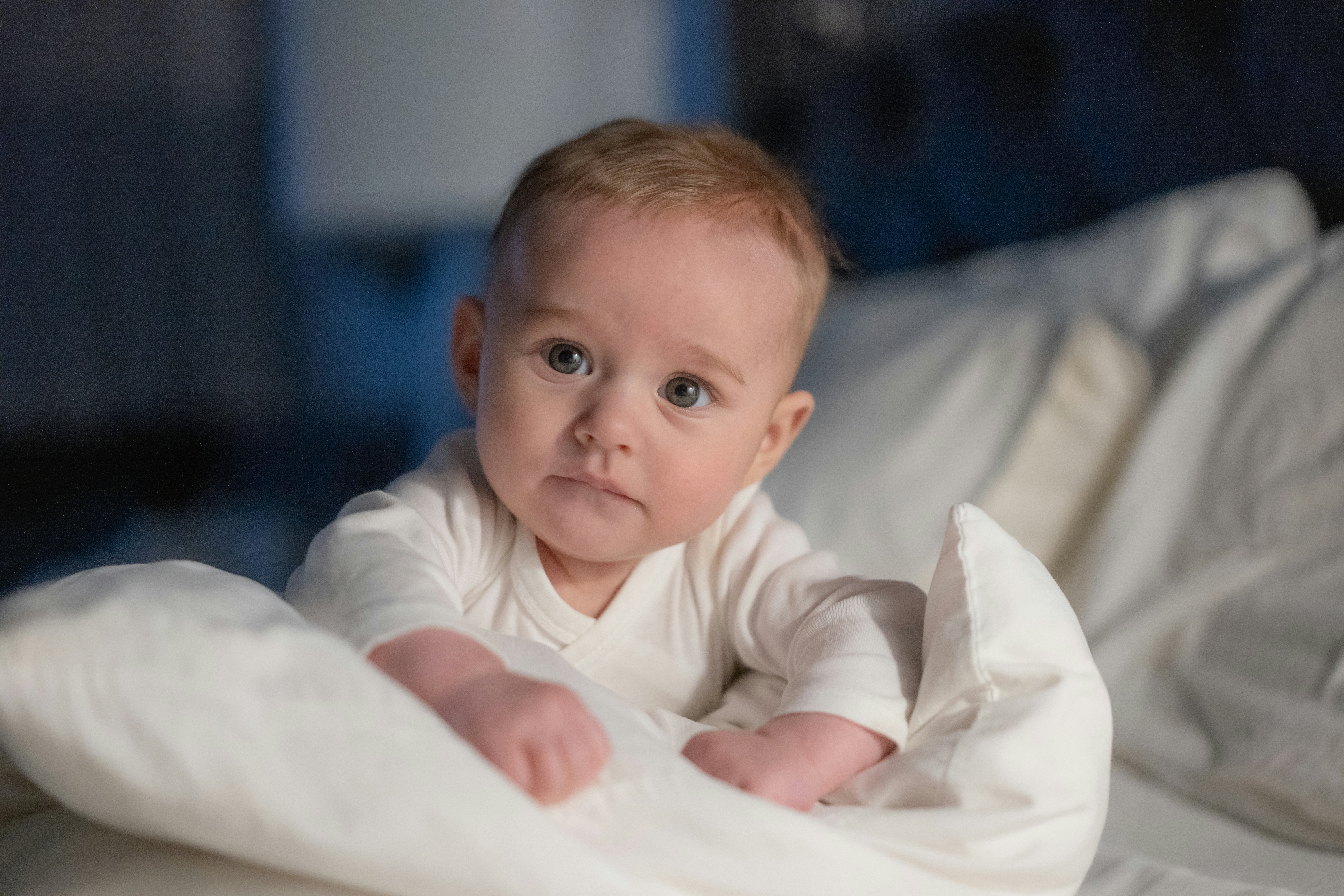 A baby wrapped in a blanket on a bed