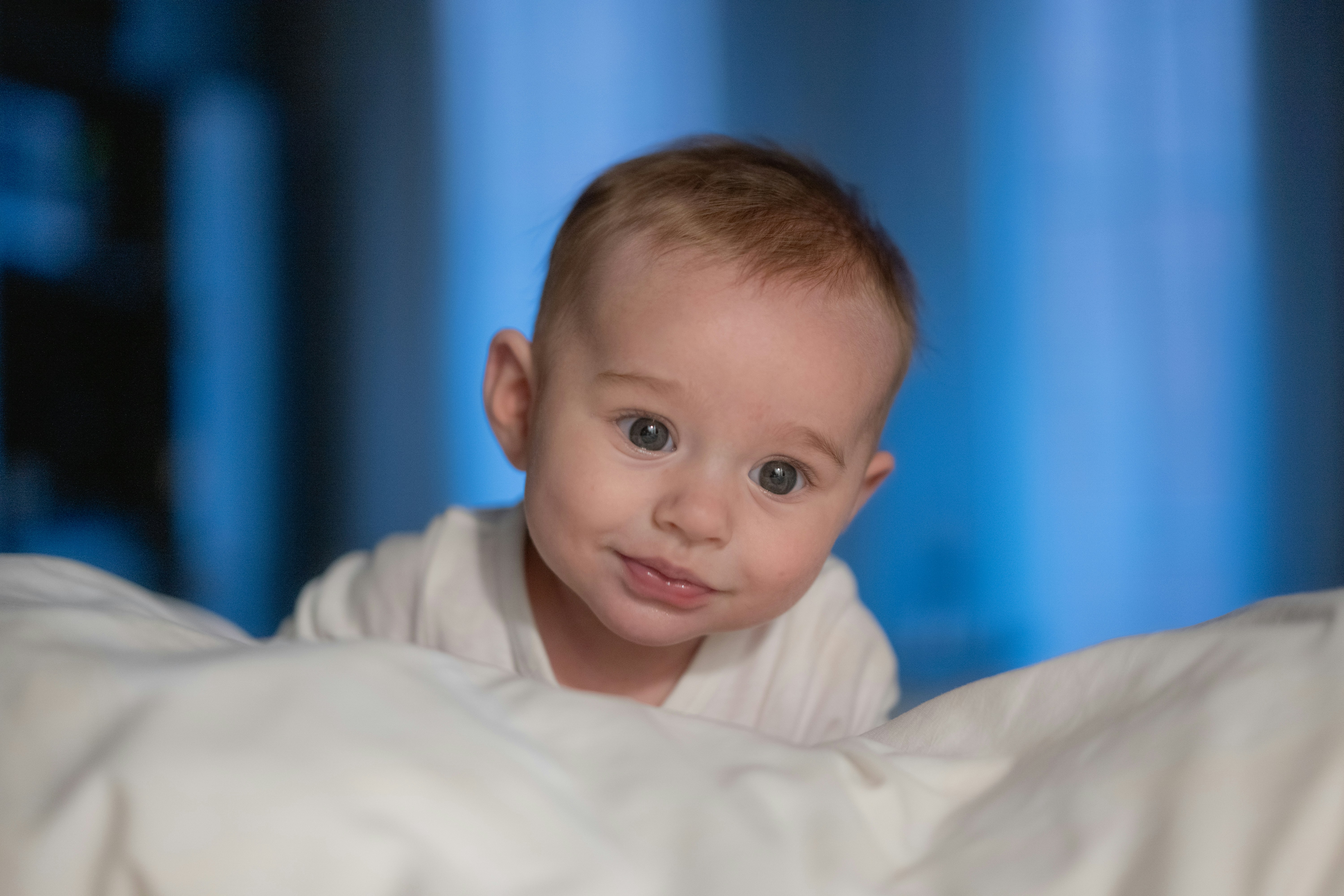 A baby is laying in a white blanket