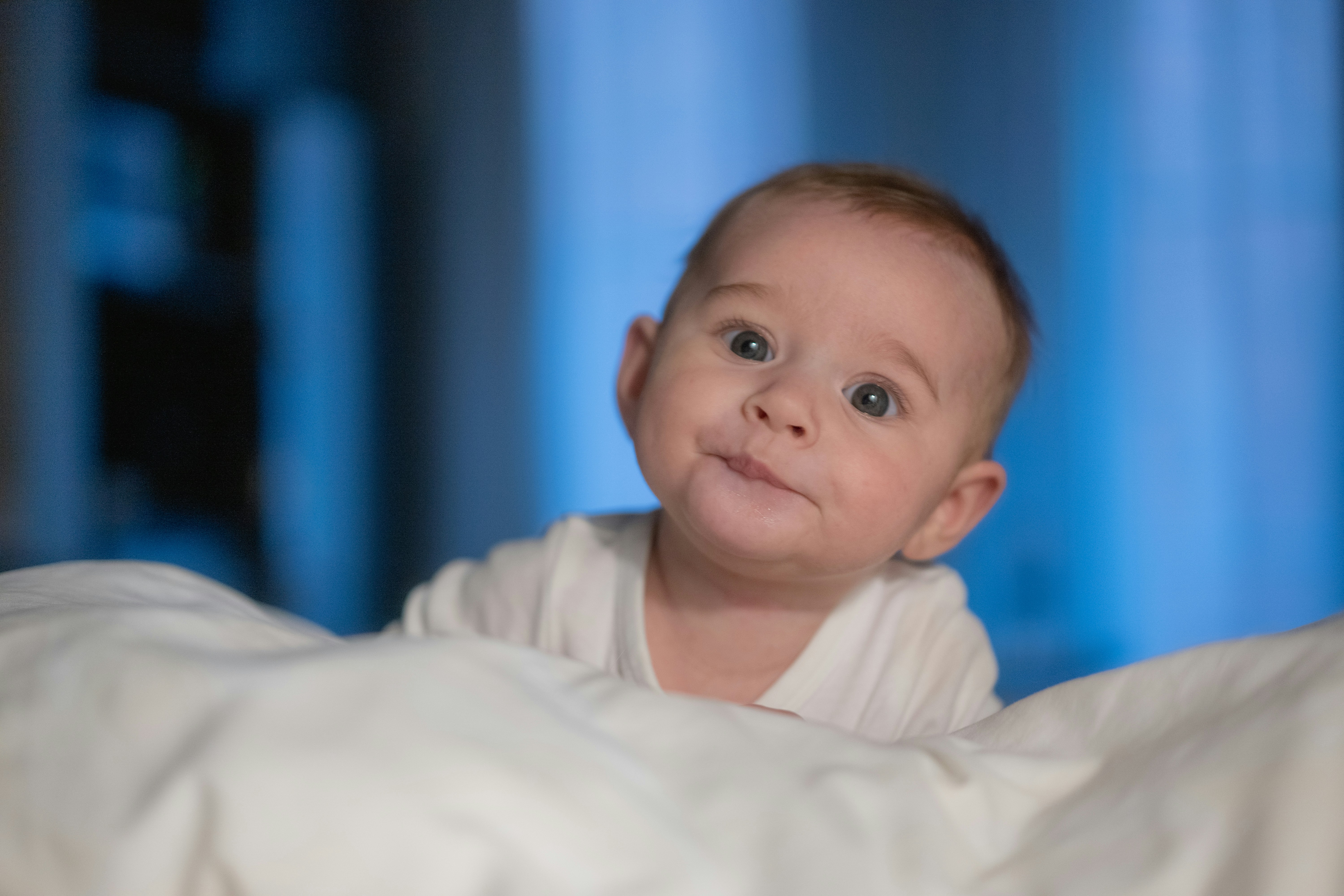 A baby wrapped in a blanket looking at the camera