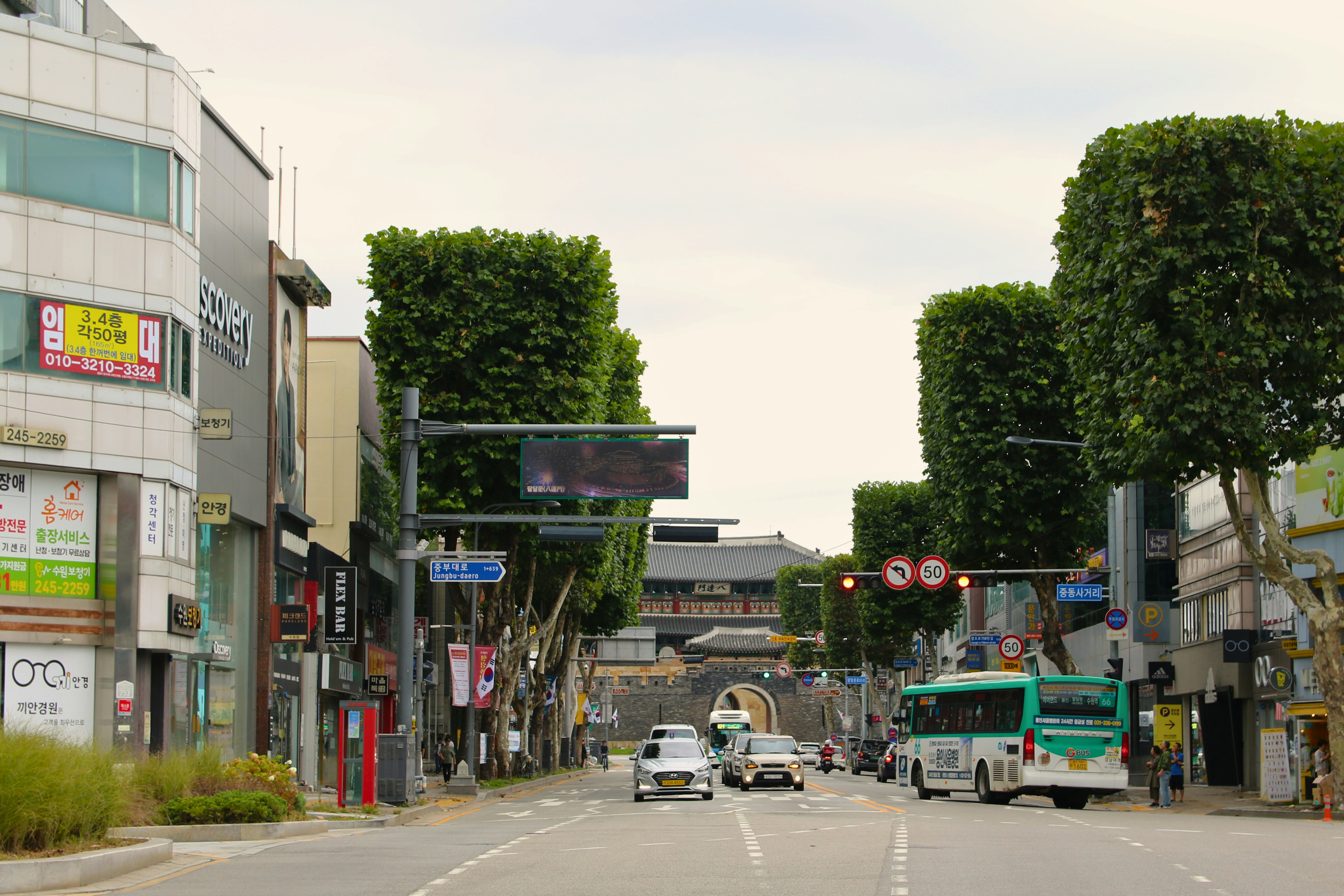 A city street filled with traffic next to tall buildings
