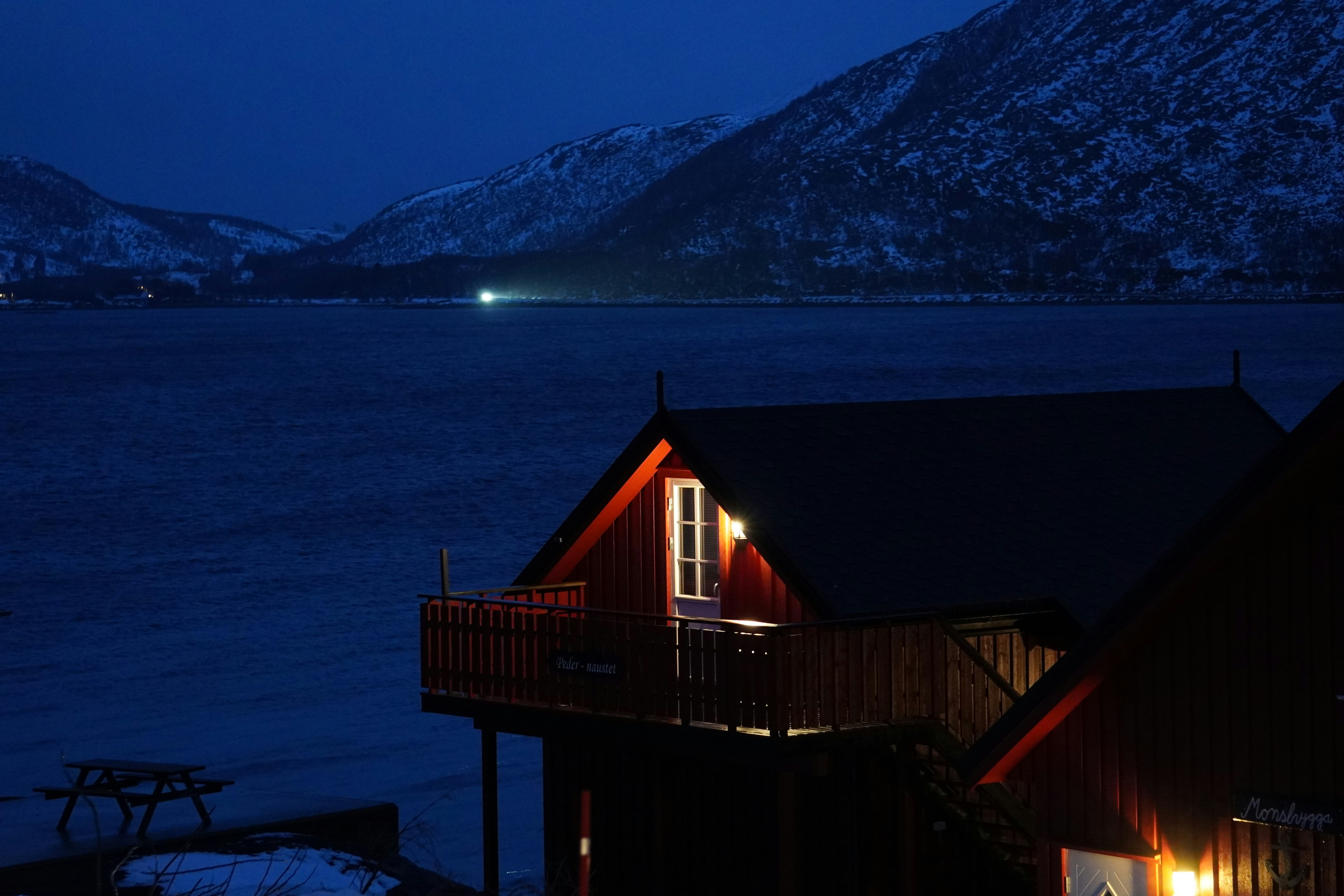 A night time view of a house next to a body of water