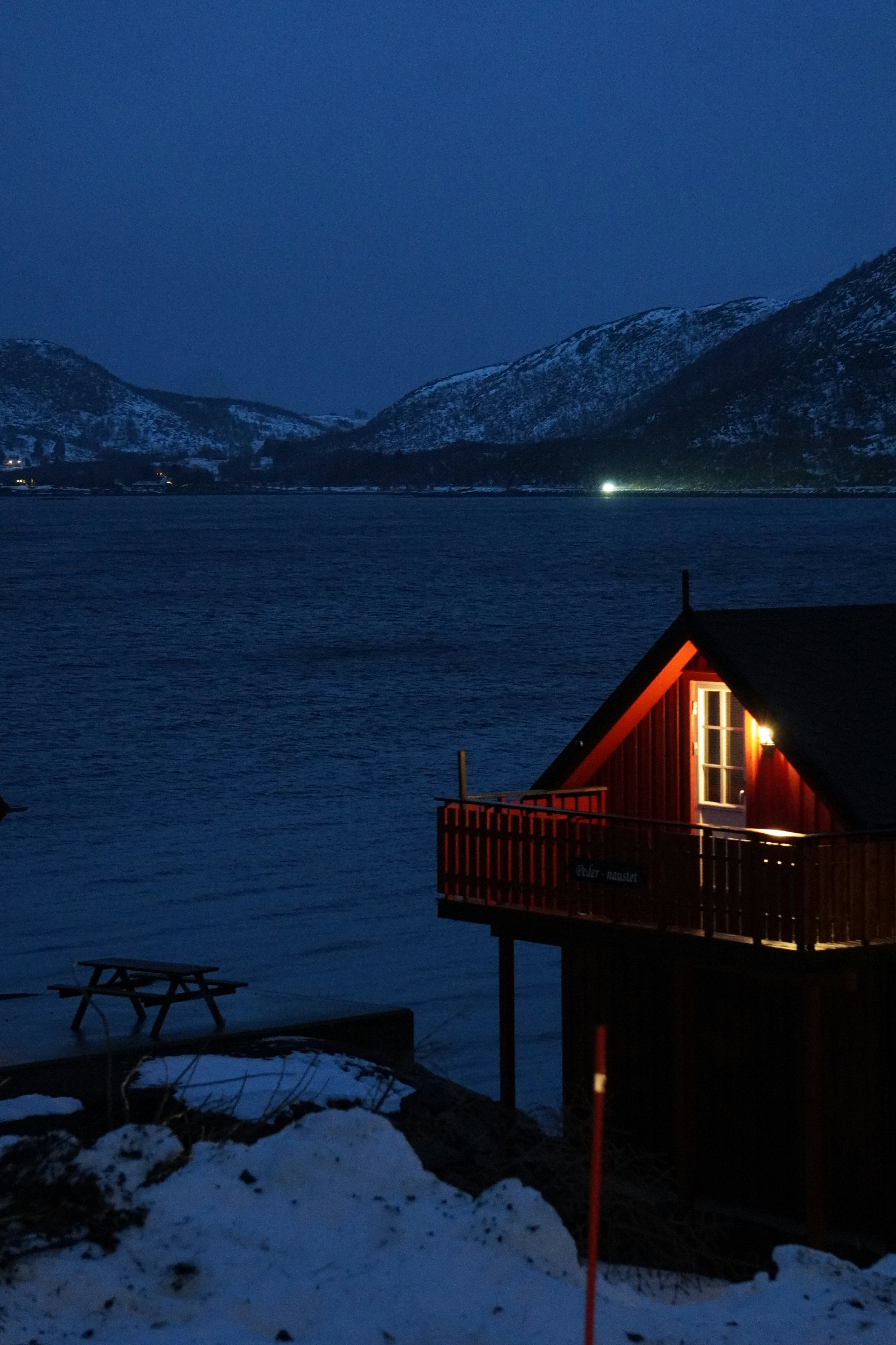 A cabin on the shore of a lake at night