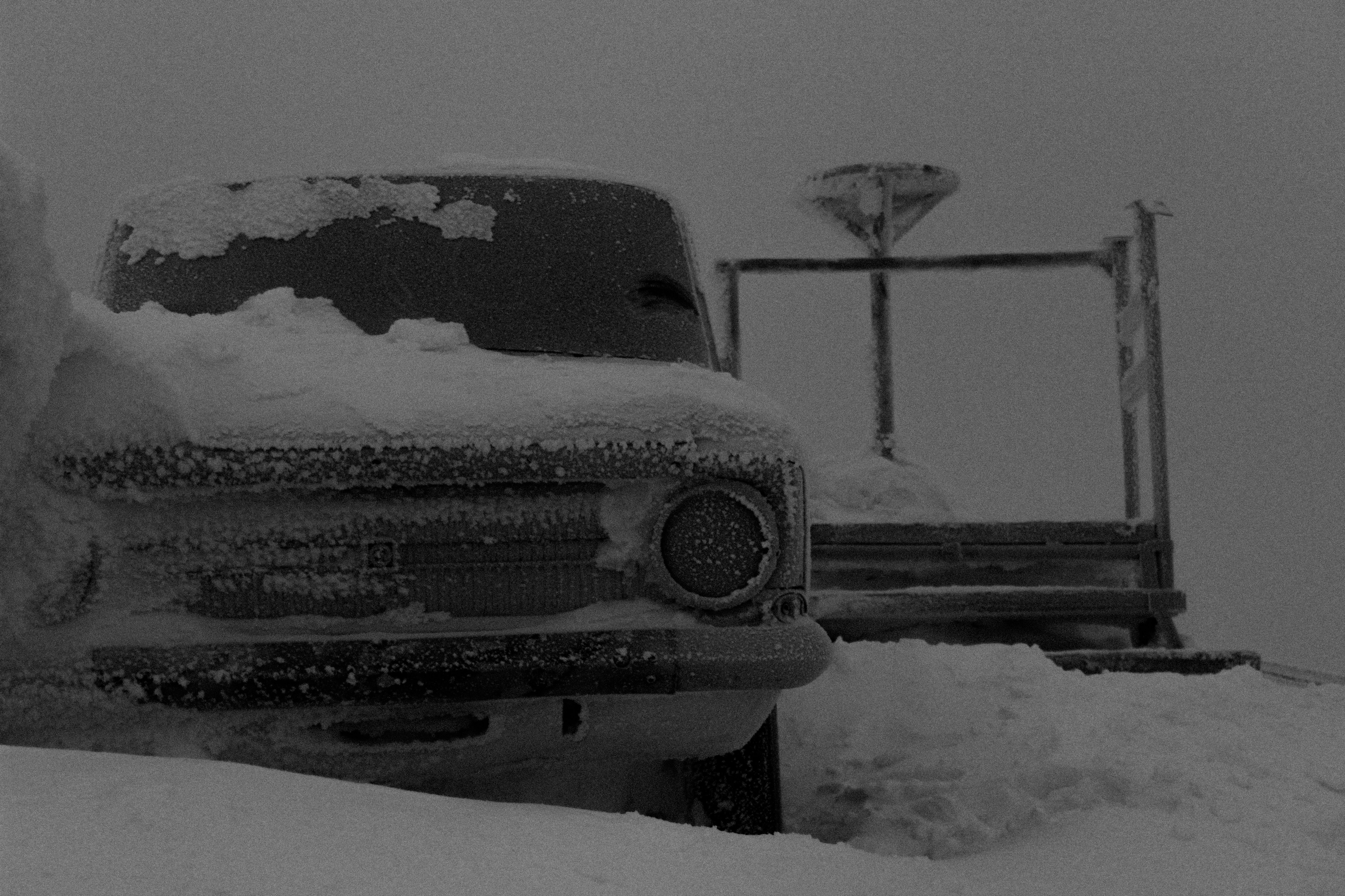 Un camion couvert de neige à côté d’une clôture