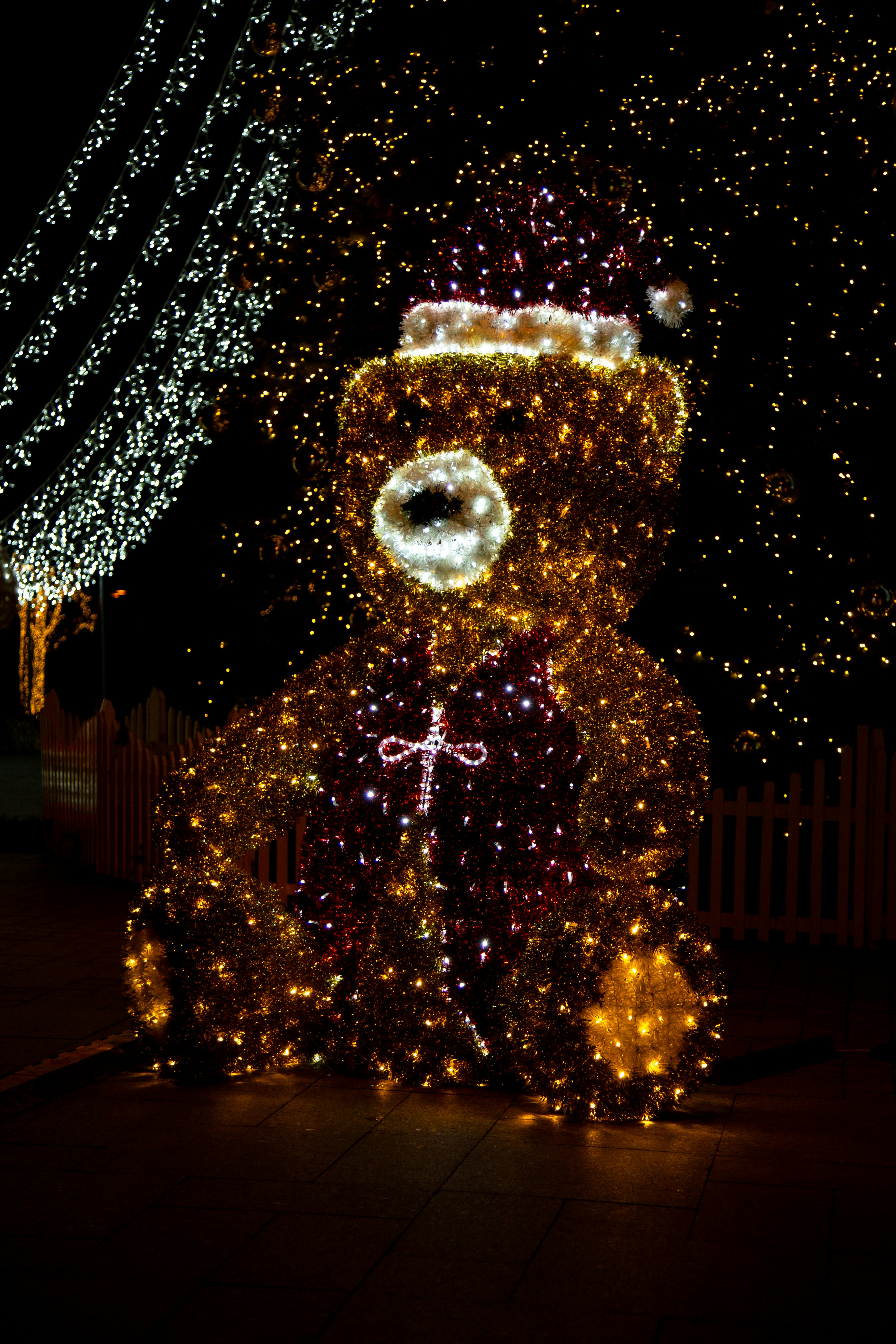 Un orsacchiotto illuminato seduto davanti a una recinzione