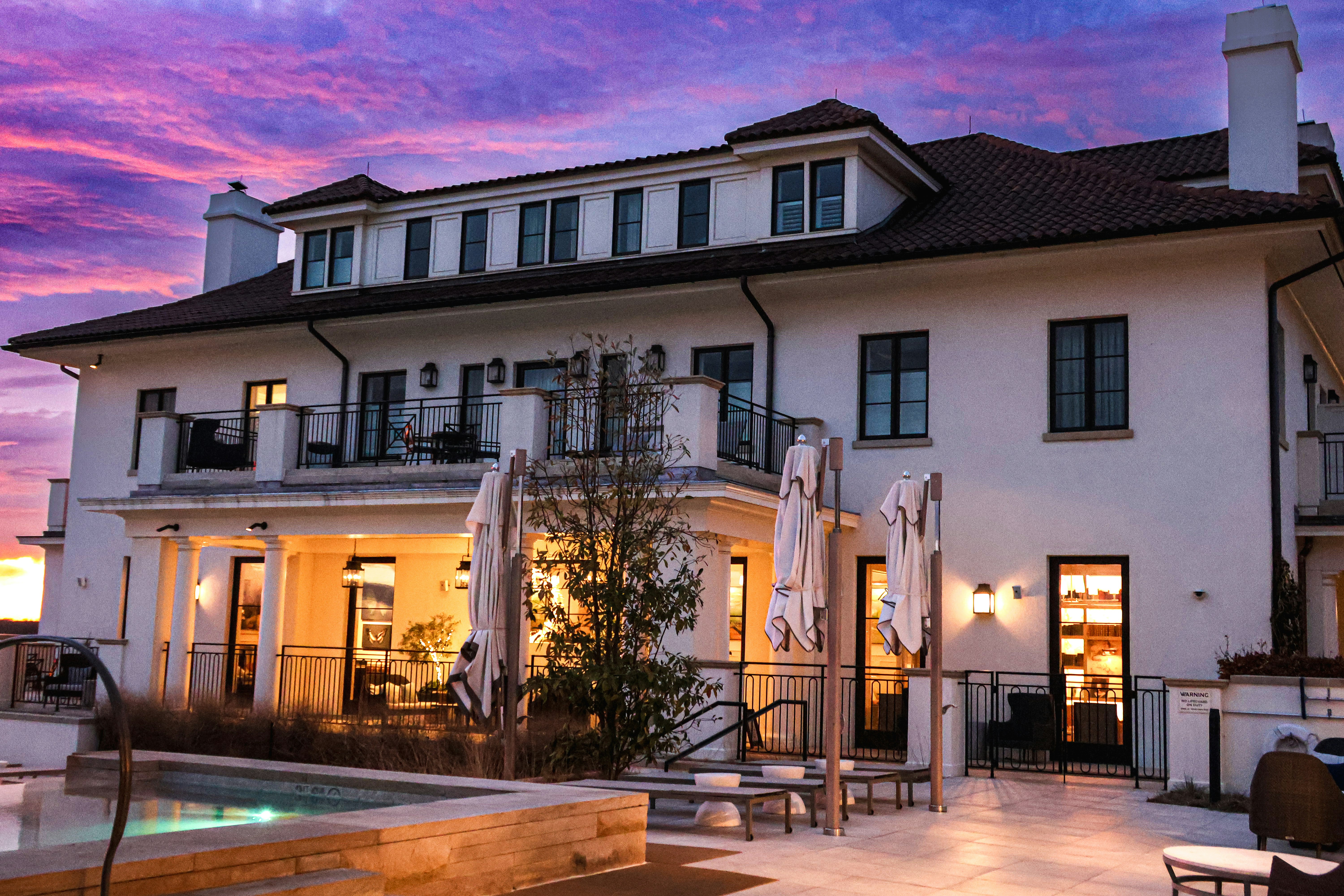 A large white building with a pool in front of it