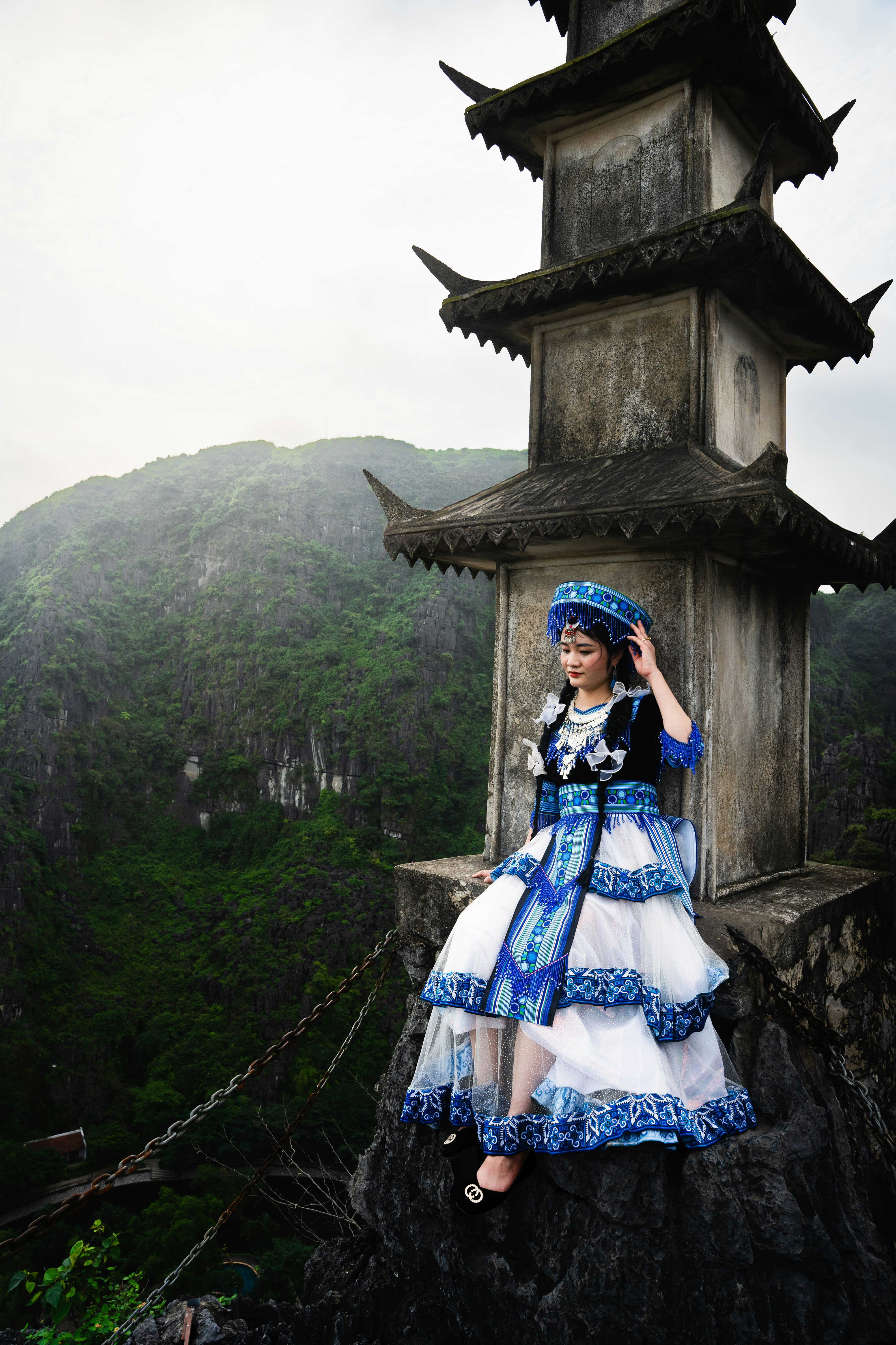 A woman in a blue and white dress standing on a rock