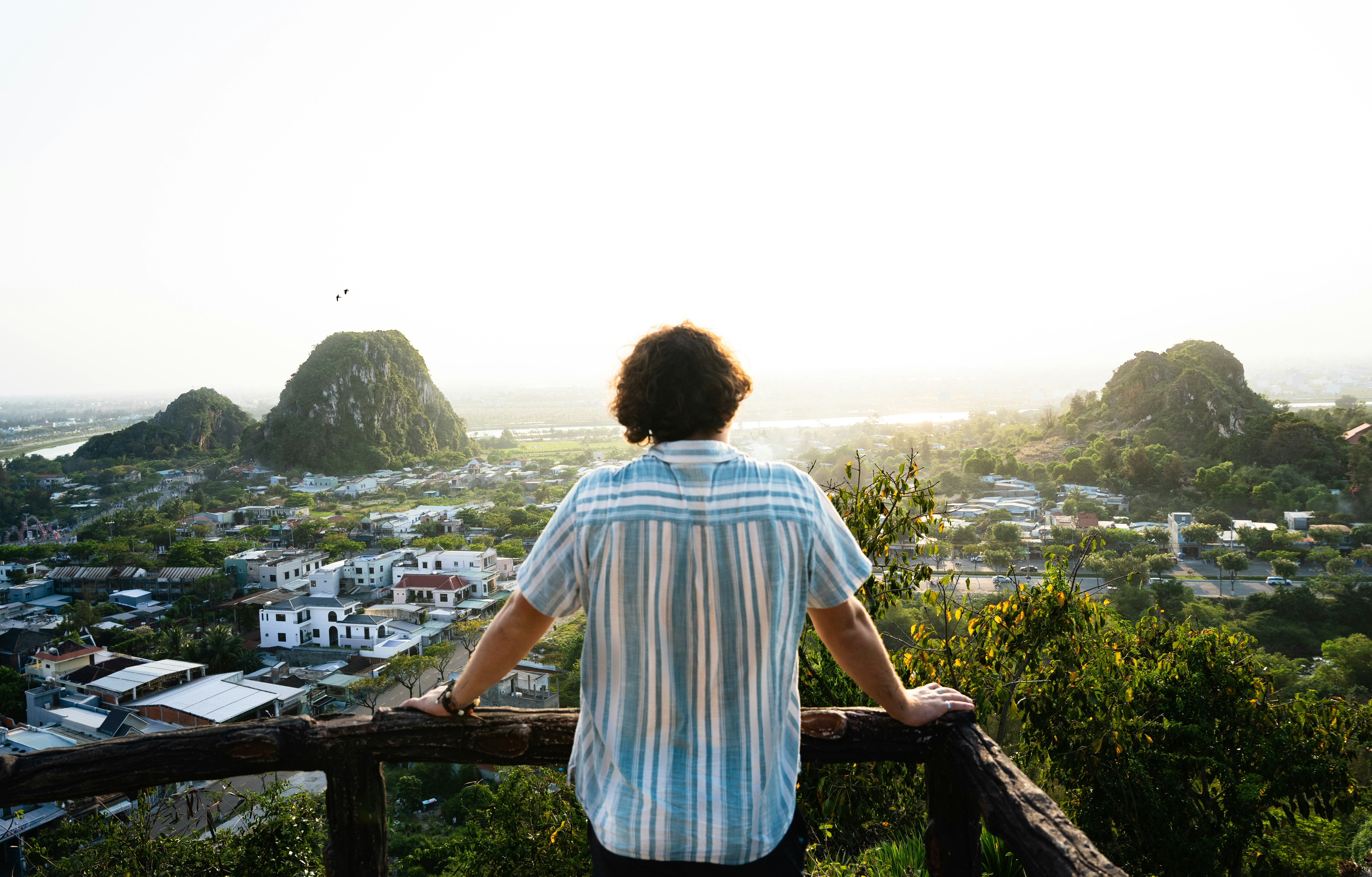 A man standing on top of a wooden railing