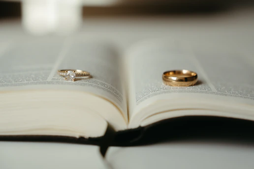 A close up of two wedding rings on an open book