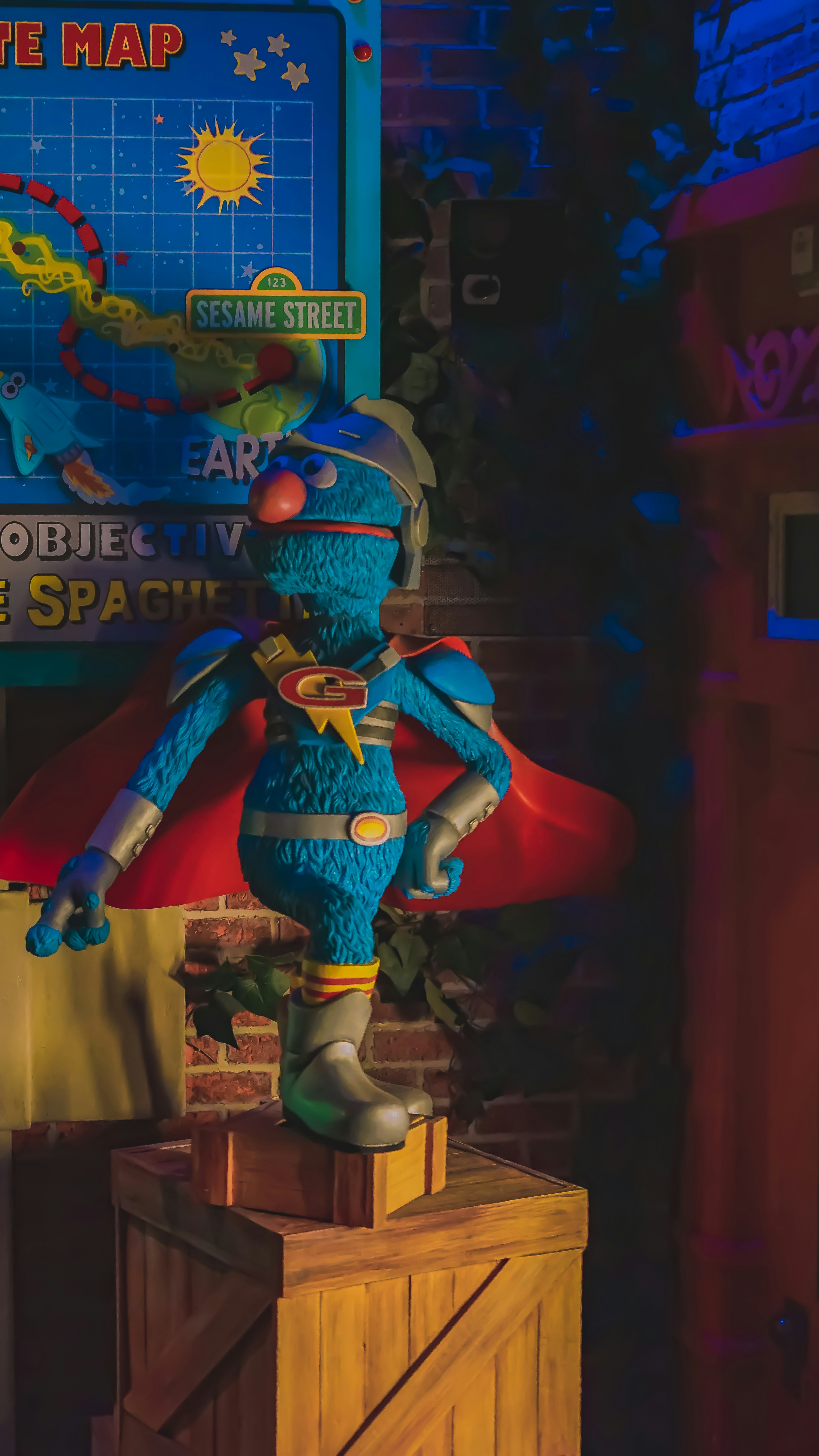 A blue and yellow stuffed animal sitting on top of a wooden box