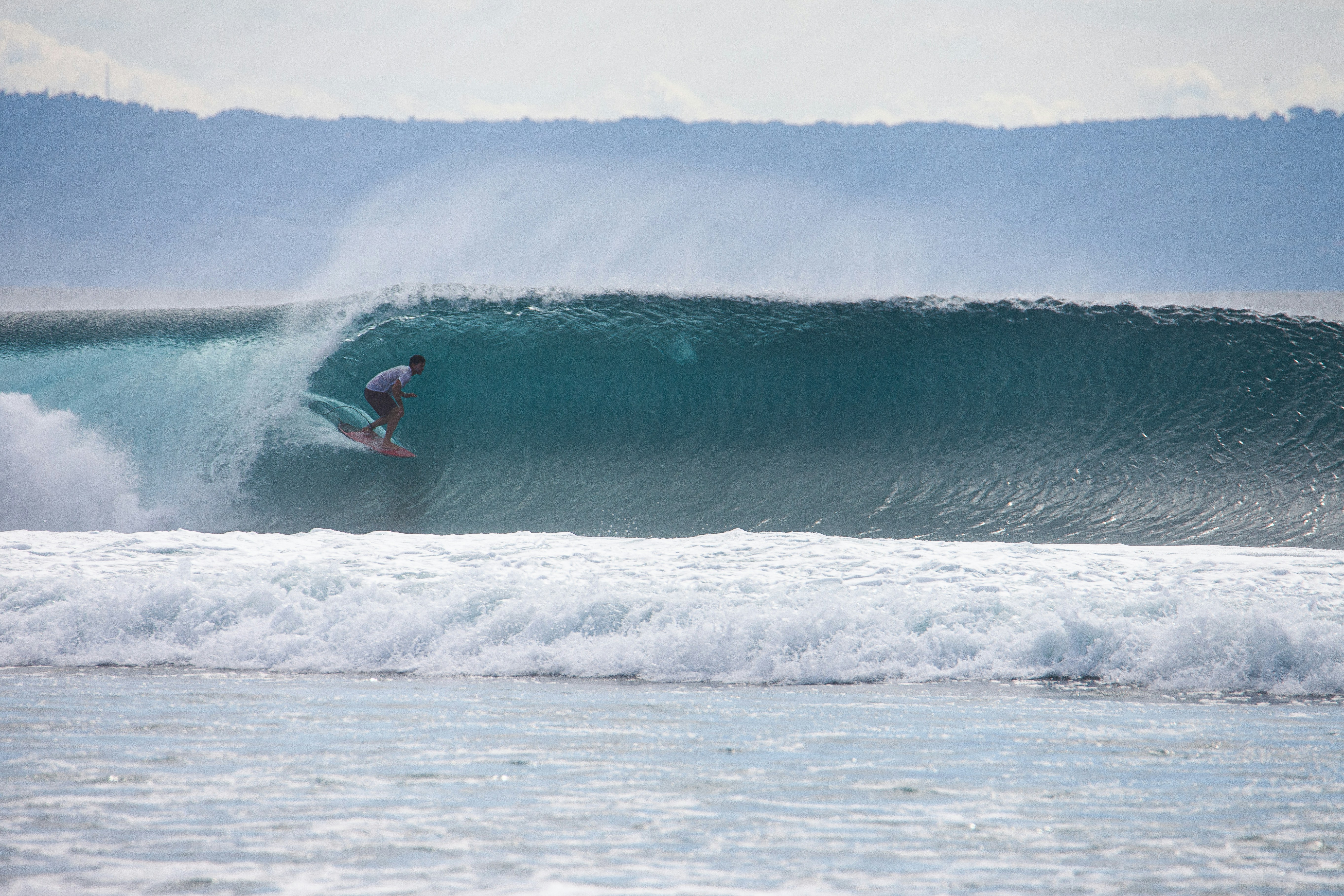 A man riding a wave on top of a surfboard