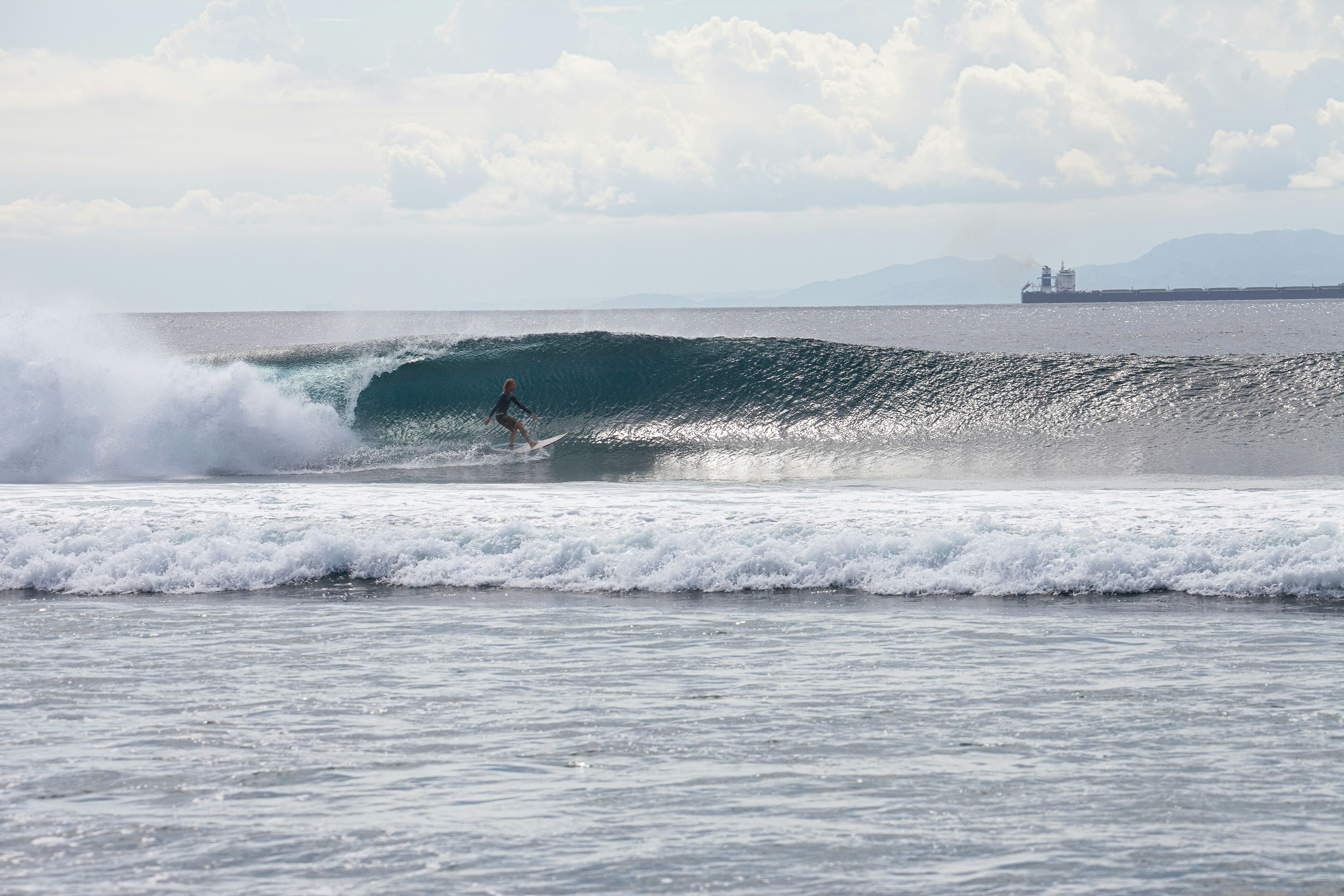 A man riding a wave on top of a surfboard