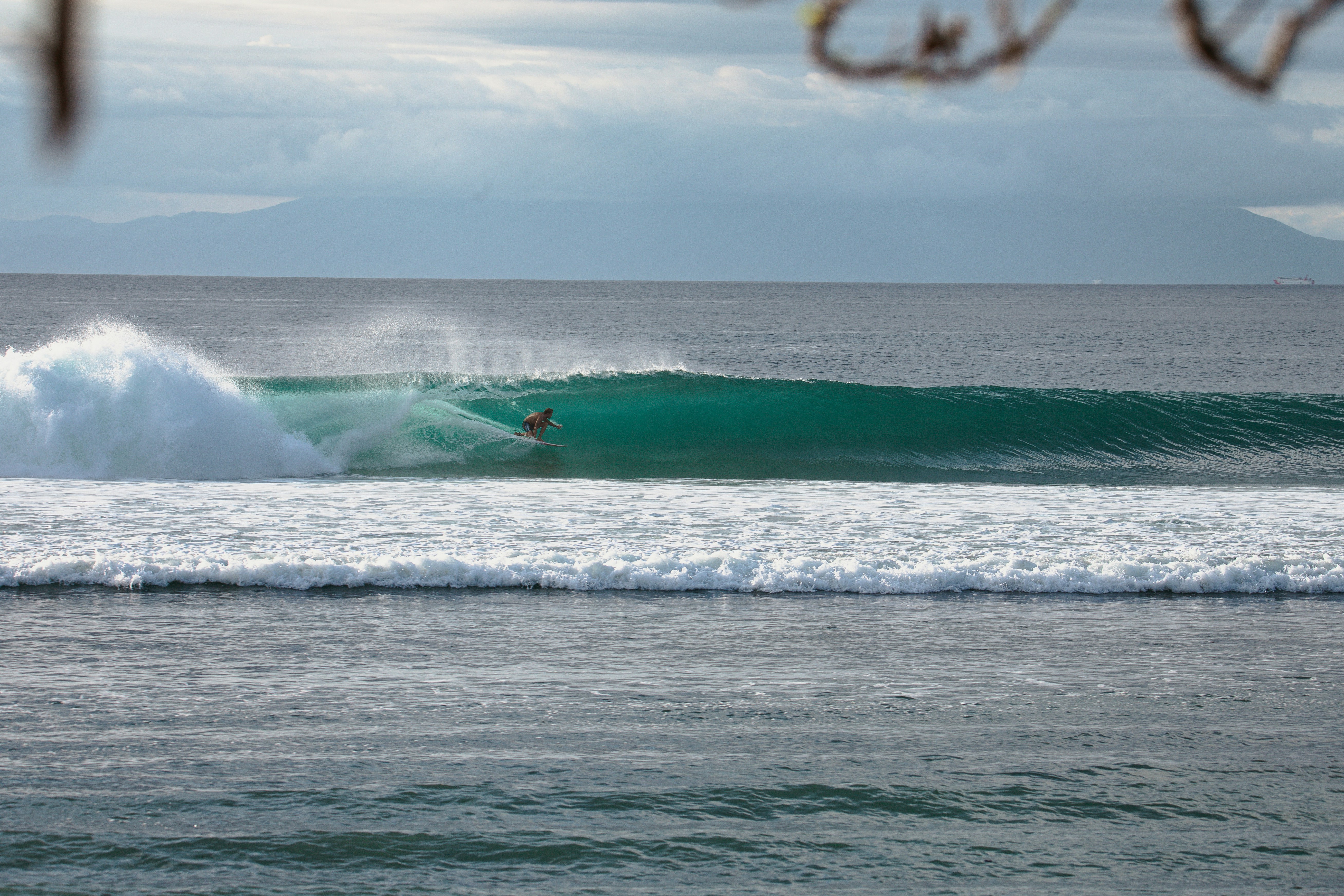 A man riding a wave on top of a surfboard