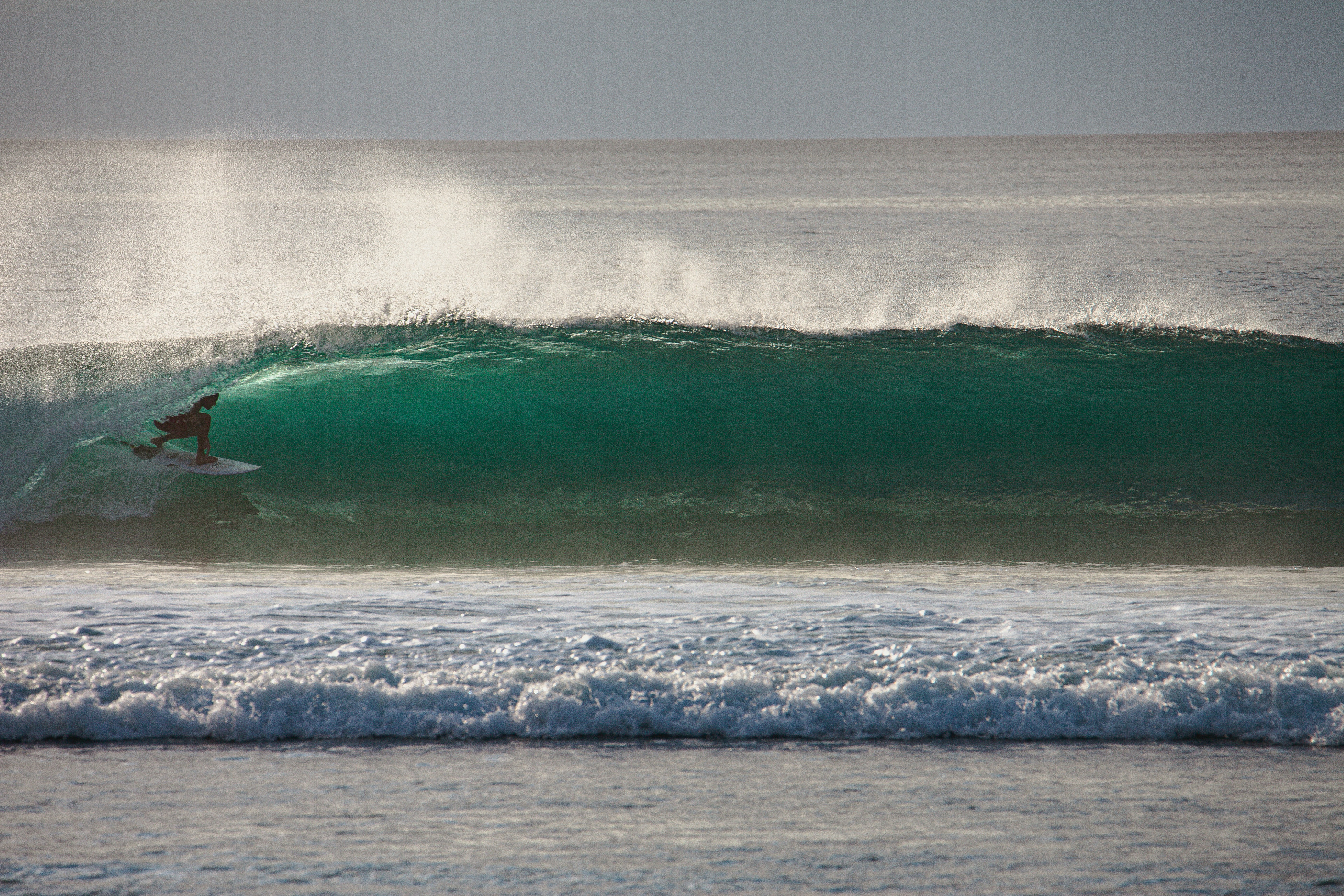 A man riding a wave on top of a surfboard