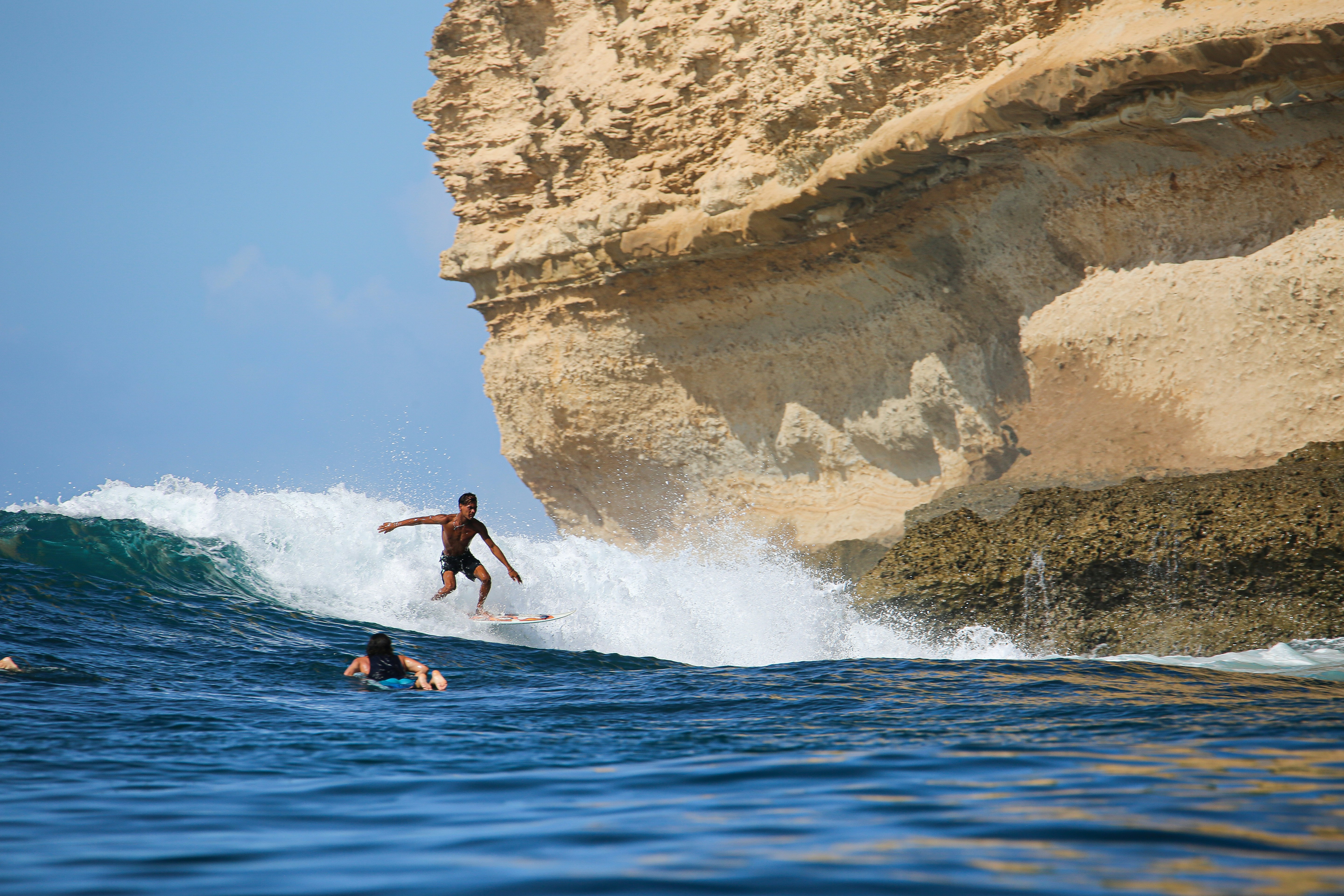 A man riding a wave on top of a surfboard