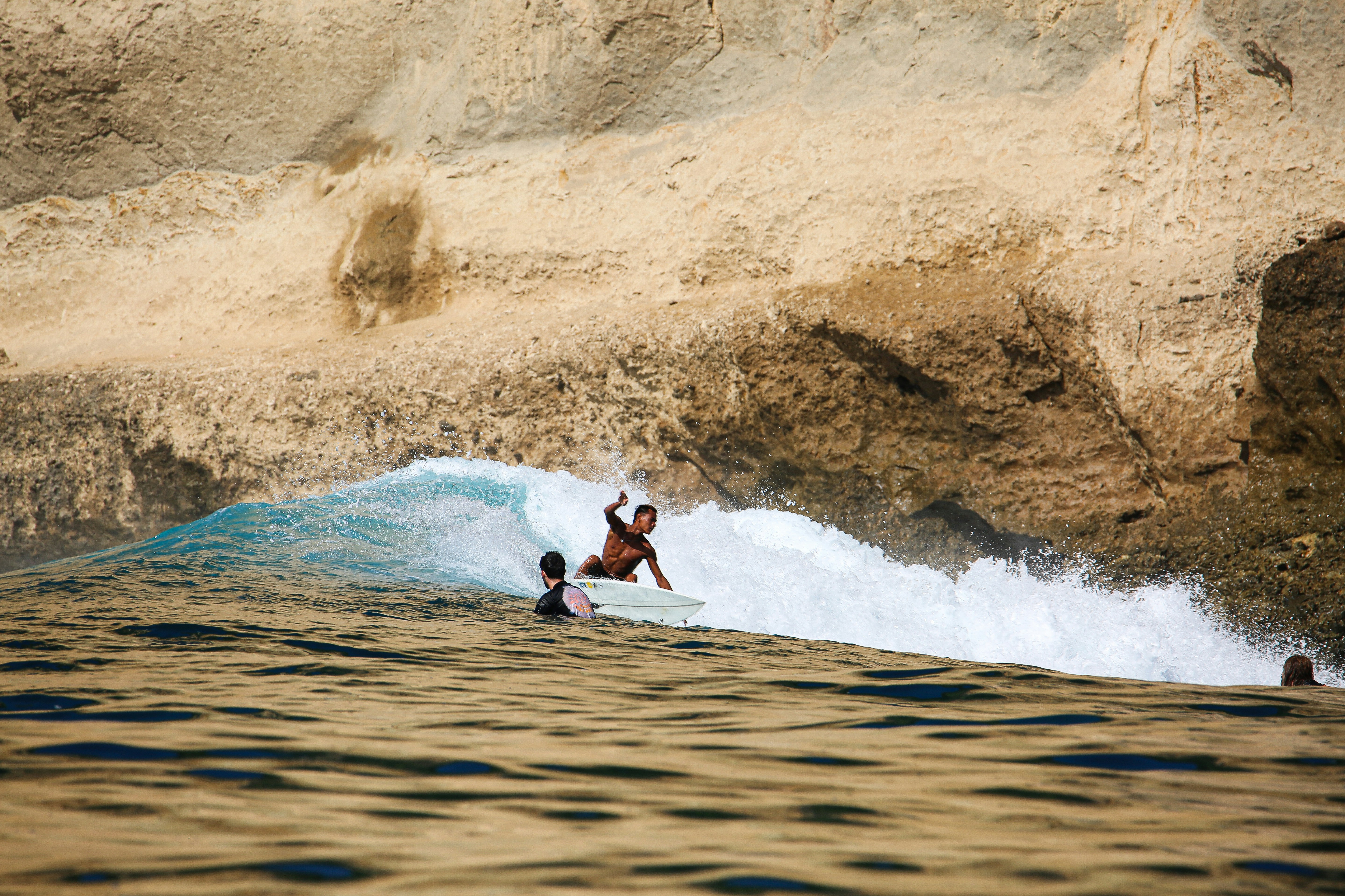 A man riding a wave on top of a surfboard