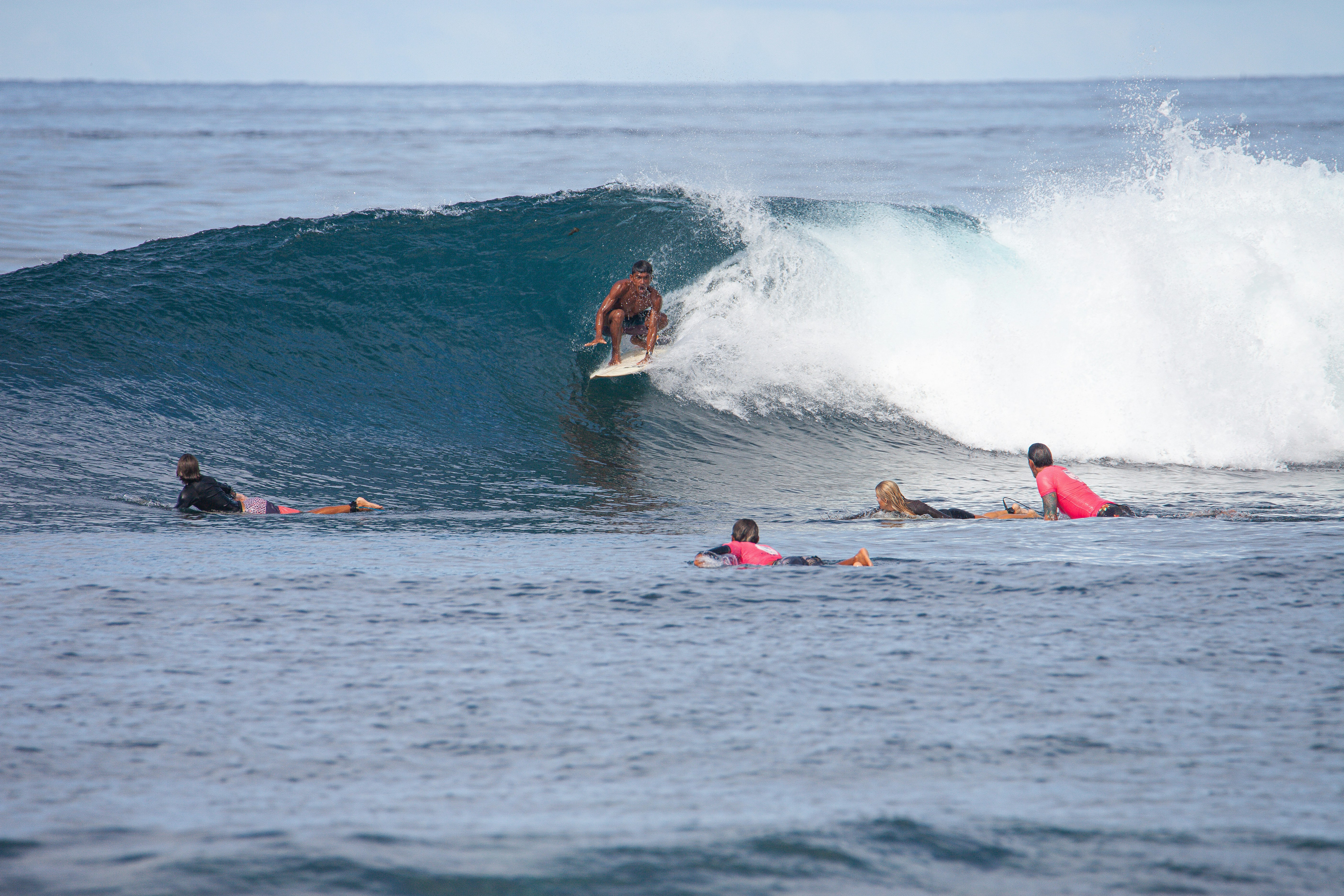 A man riding a wave on top of a surfboard
