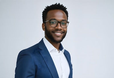 A man in a suit and glasses smiling