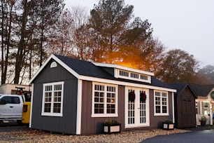 A small gray and white house next to a white truck