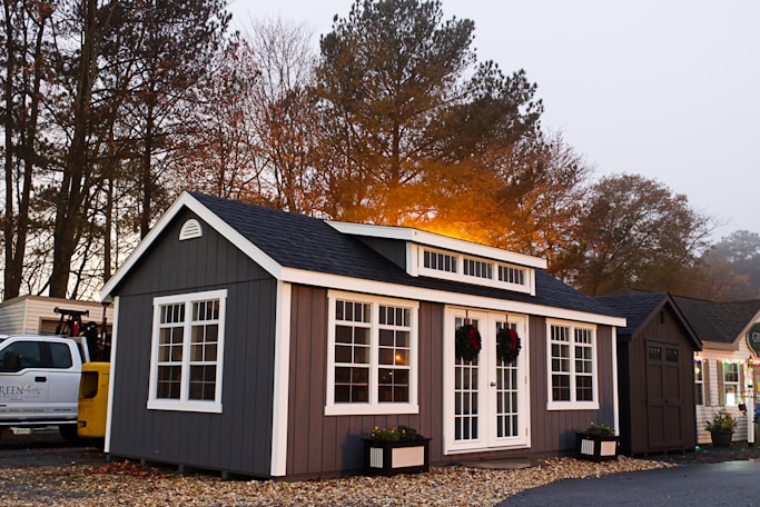 A small gray and white house next to a white truck
