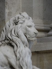 A statue of a lion sitting in front of a building