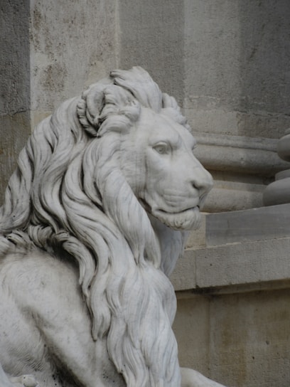 A statue of a lion sitting in front of a building