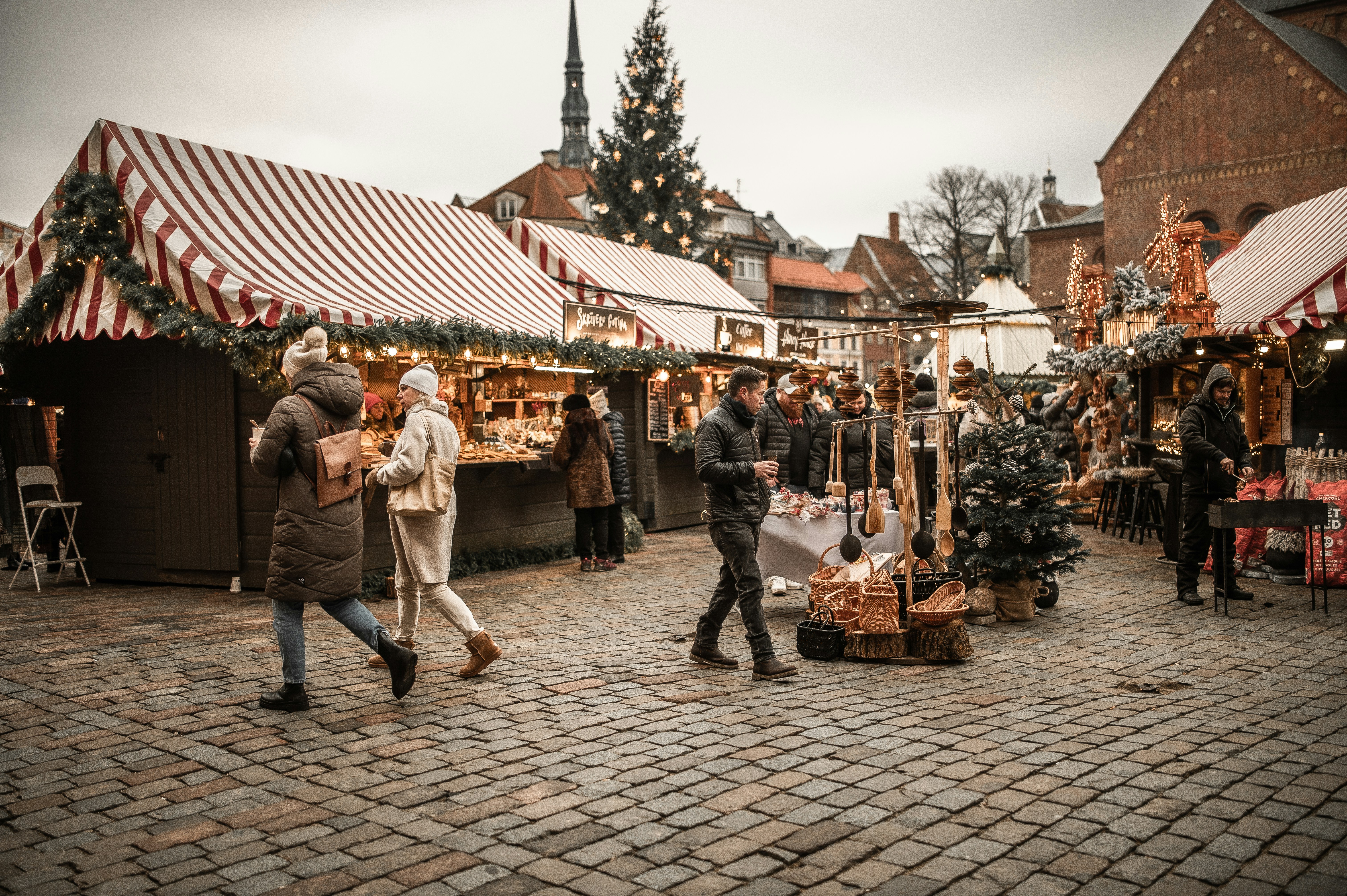 A group of people walking around a christmas market