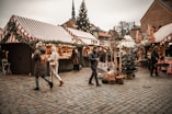 A group of people walking around a christmas market