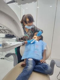 A young boy getting his teeth checked by a dentist