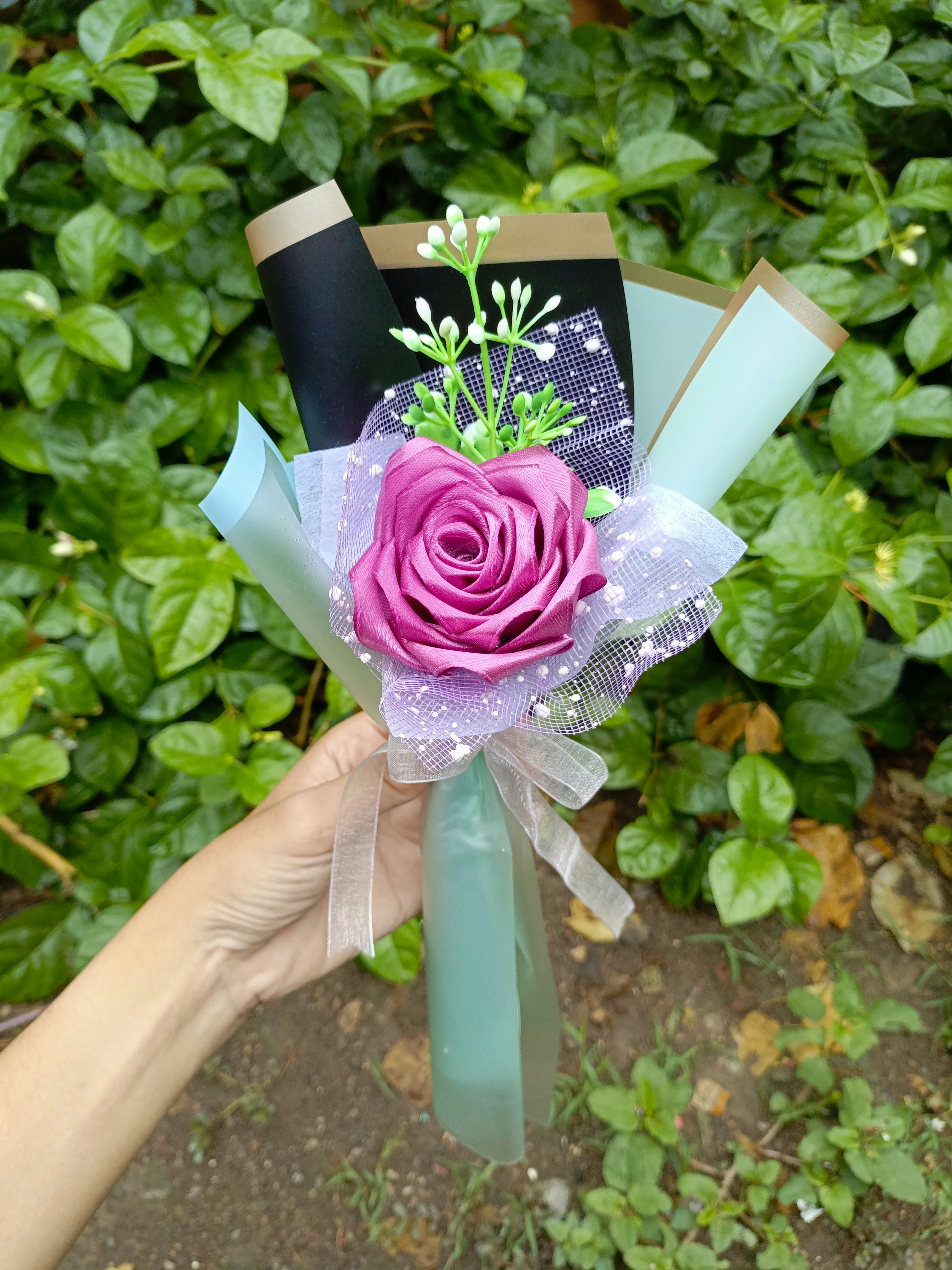 Una persona que sostiene una rosa rosa en la mano