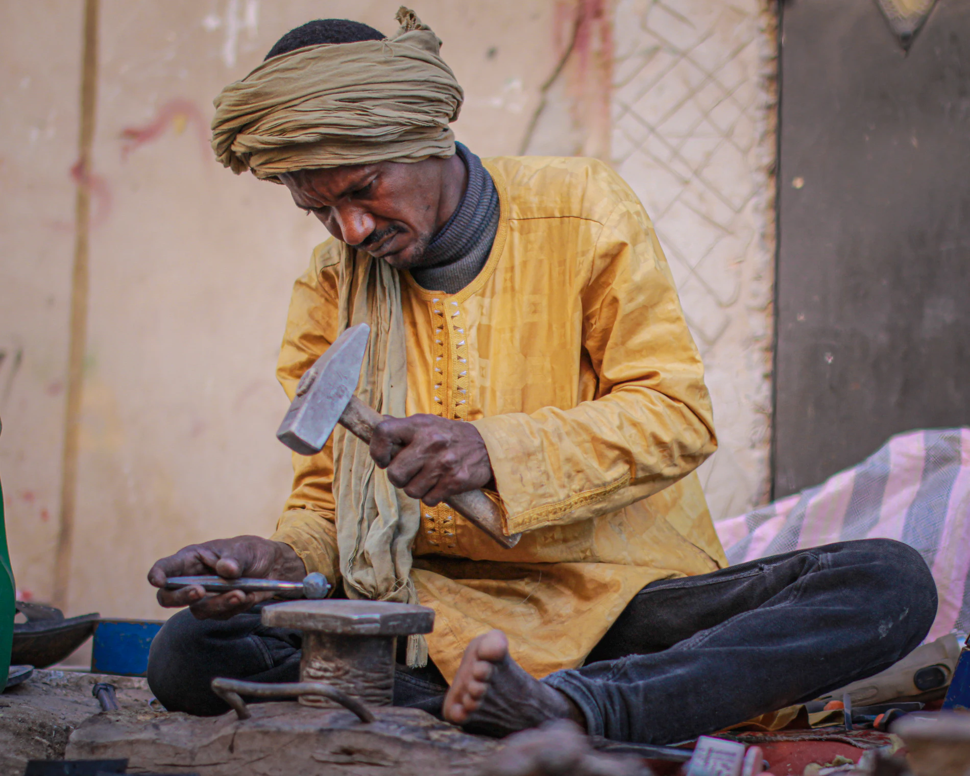 A maker working a leather upper over the last by hand