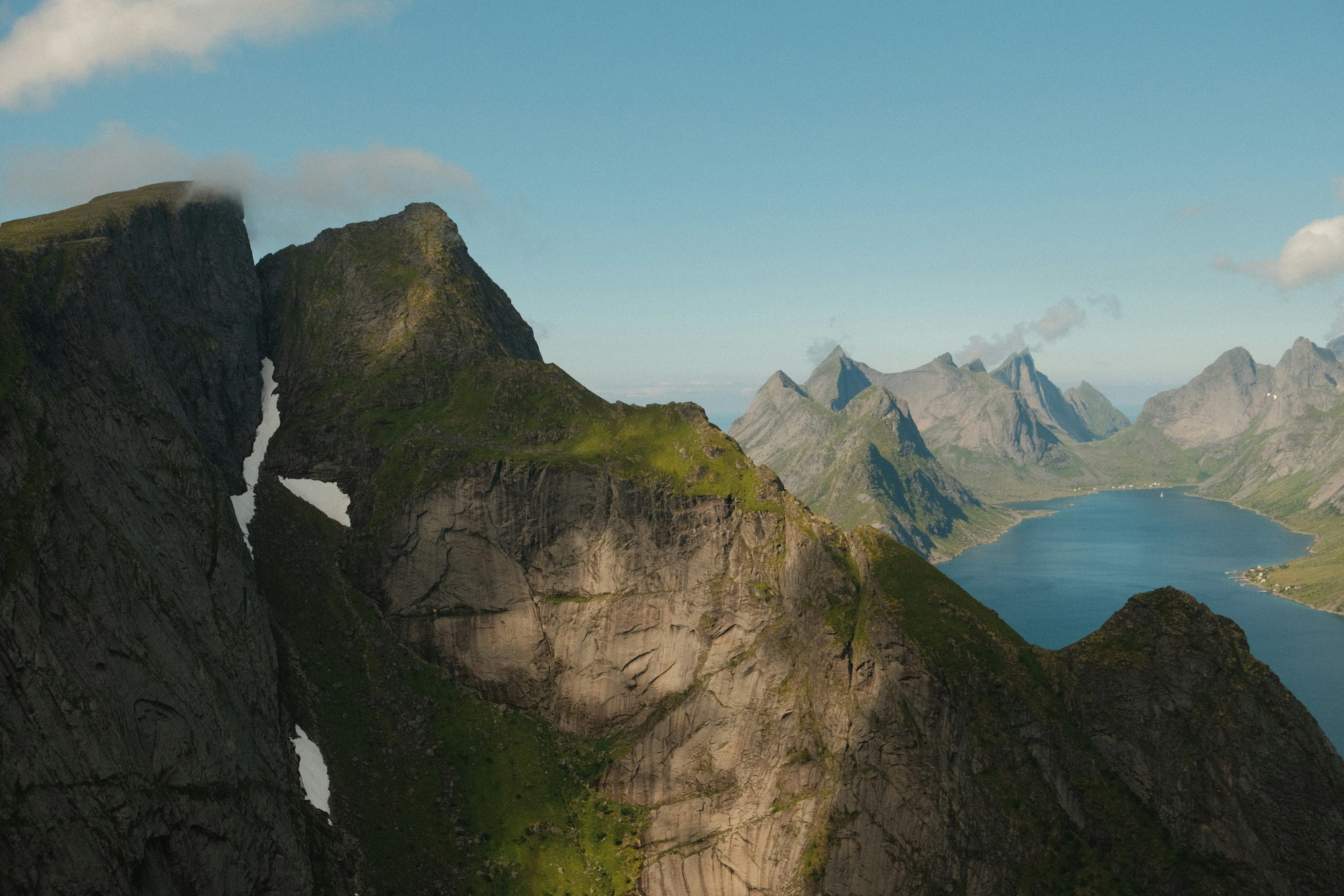An aerial view of a mountain range with a lake and mountains in the background