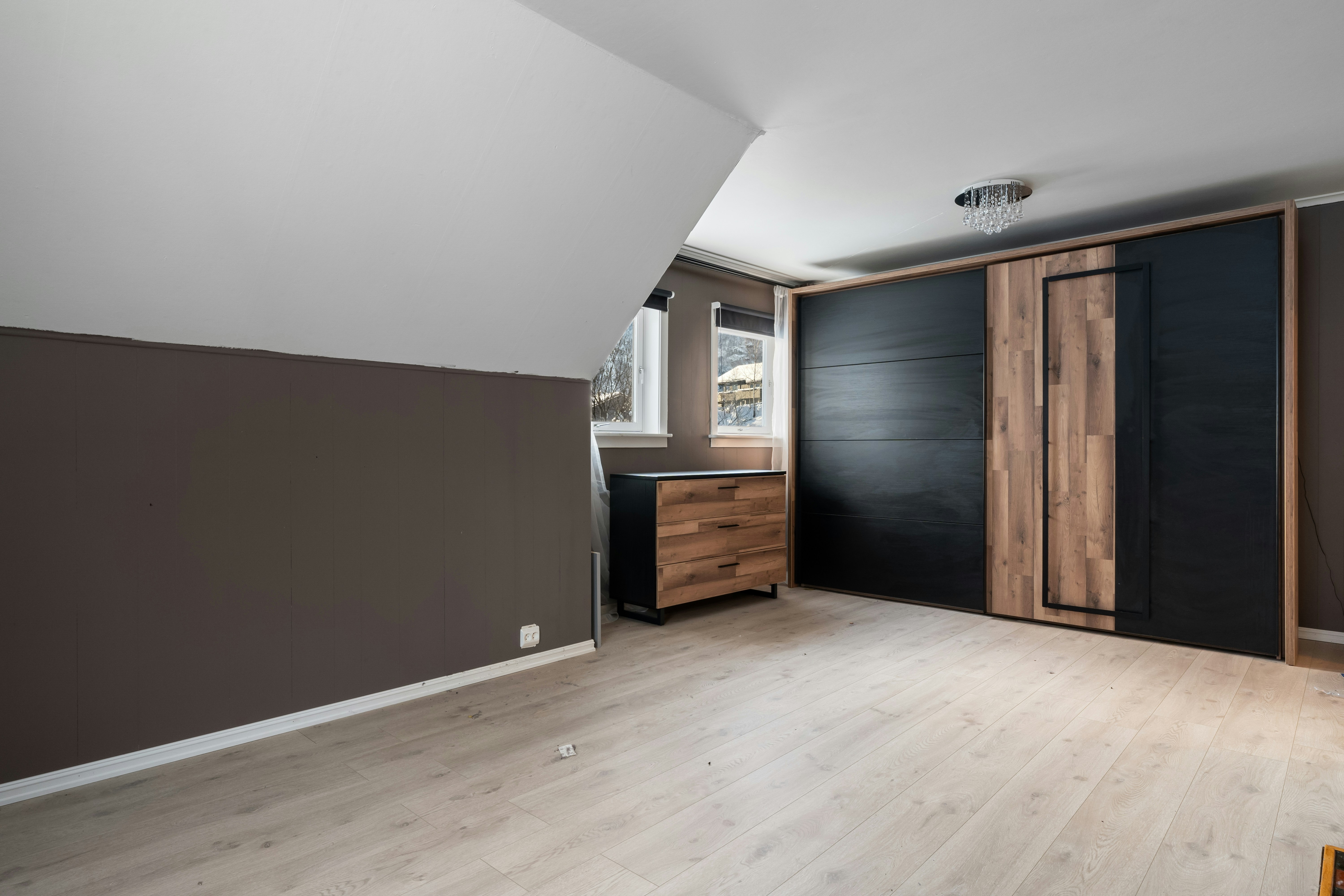An empty room with a wooden floor and black walls