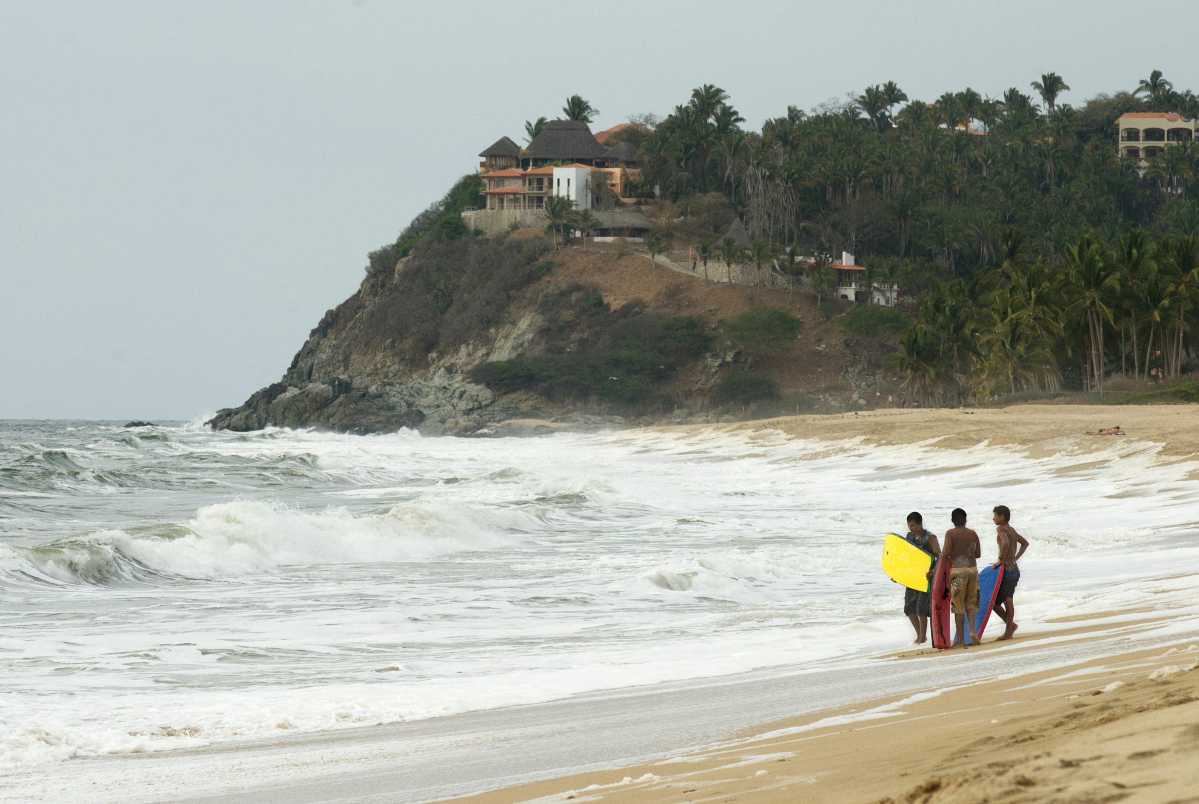 A group of people standing on top of a sandy beach