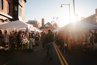 A man walking down a street next to a market