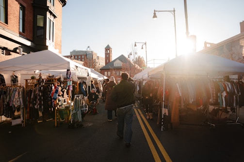 A man walking down a street next to a market