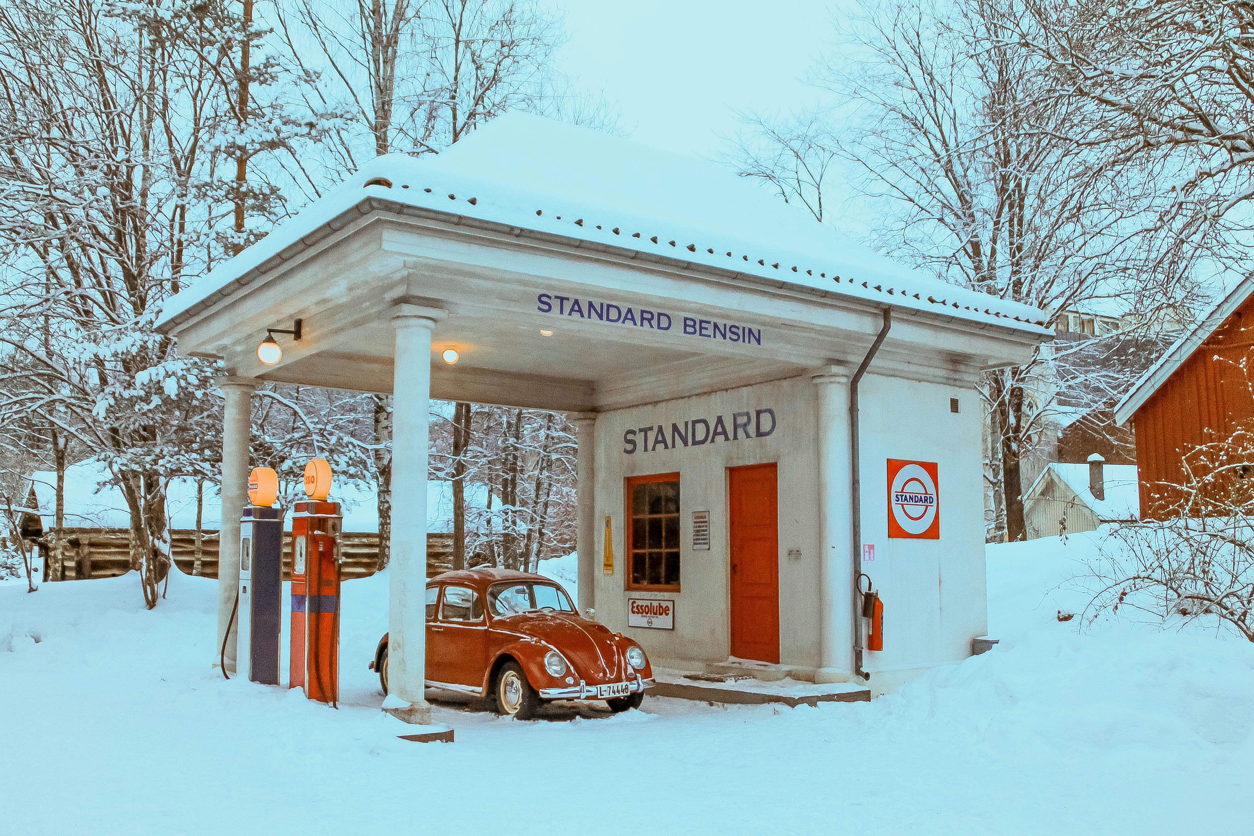 A red car parked in front of a white building