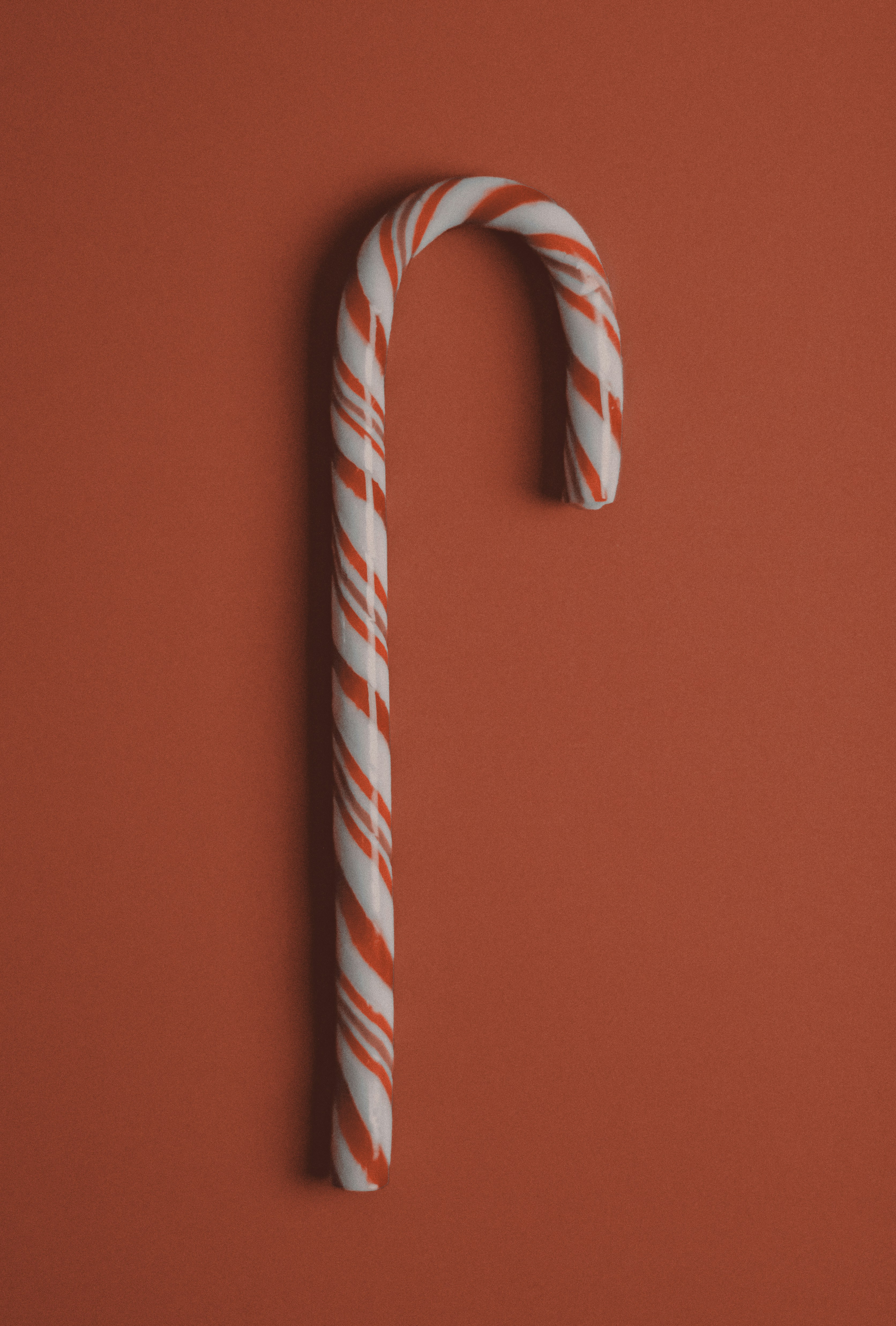 A candy cane sitting on top of a red surface