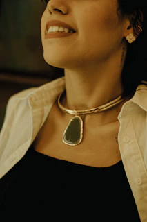 A woman wearing a necklace and a white shirt