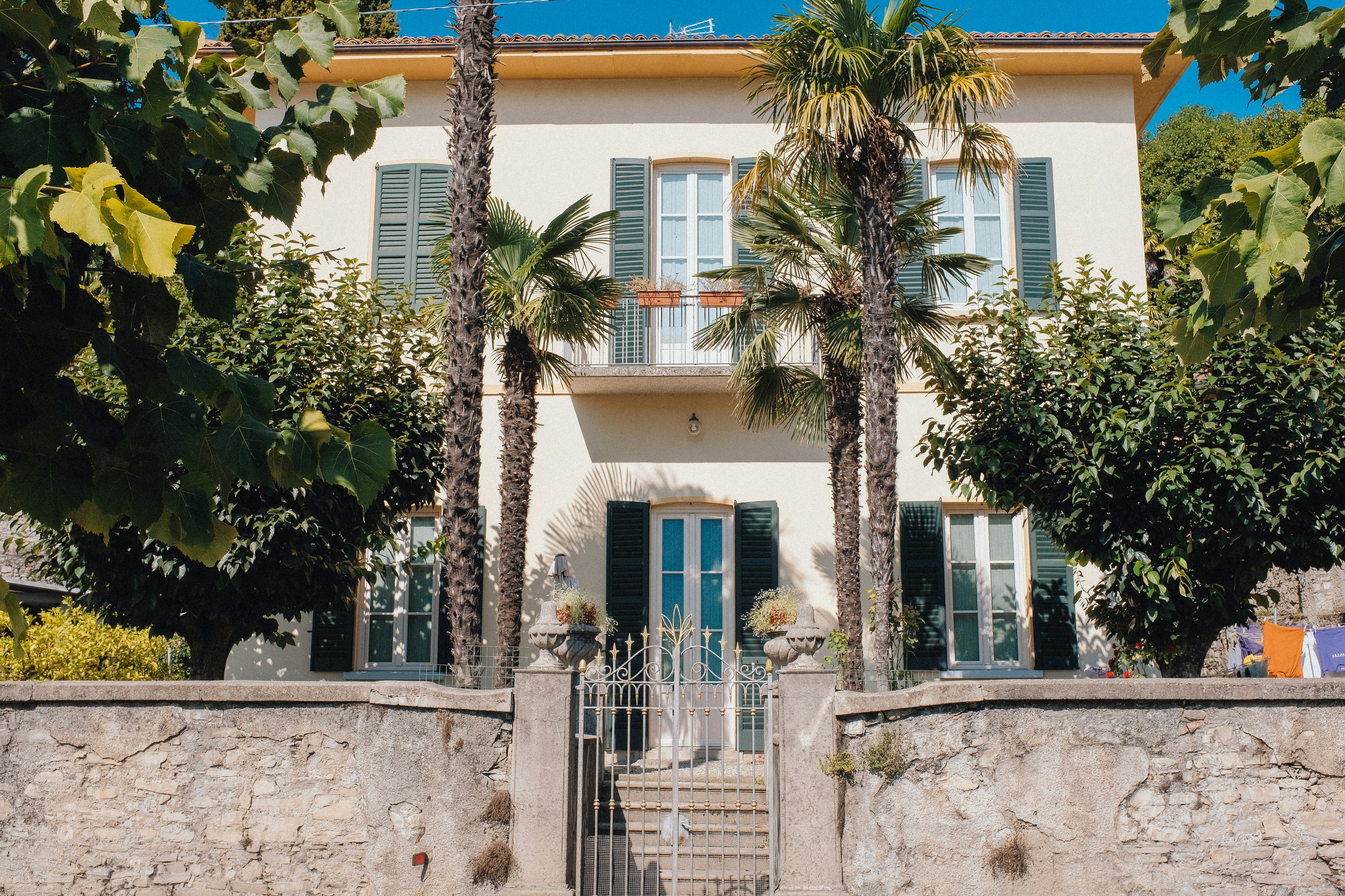 A large white house with palm trees in front of it, 