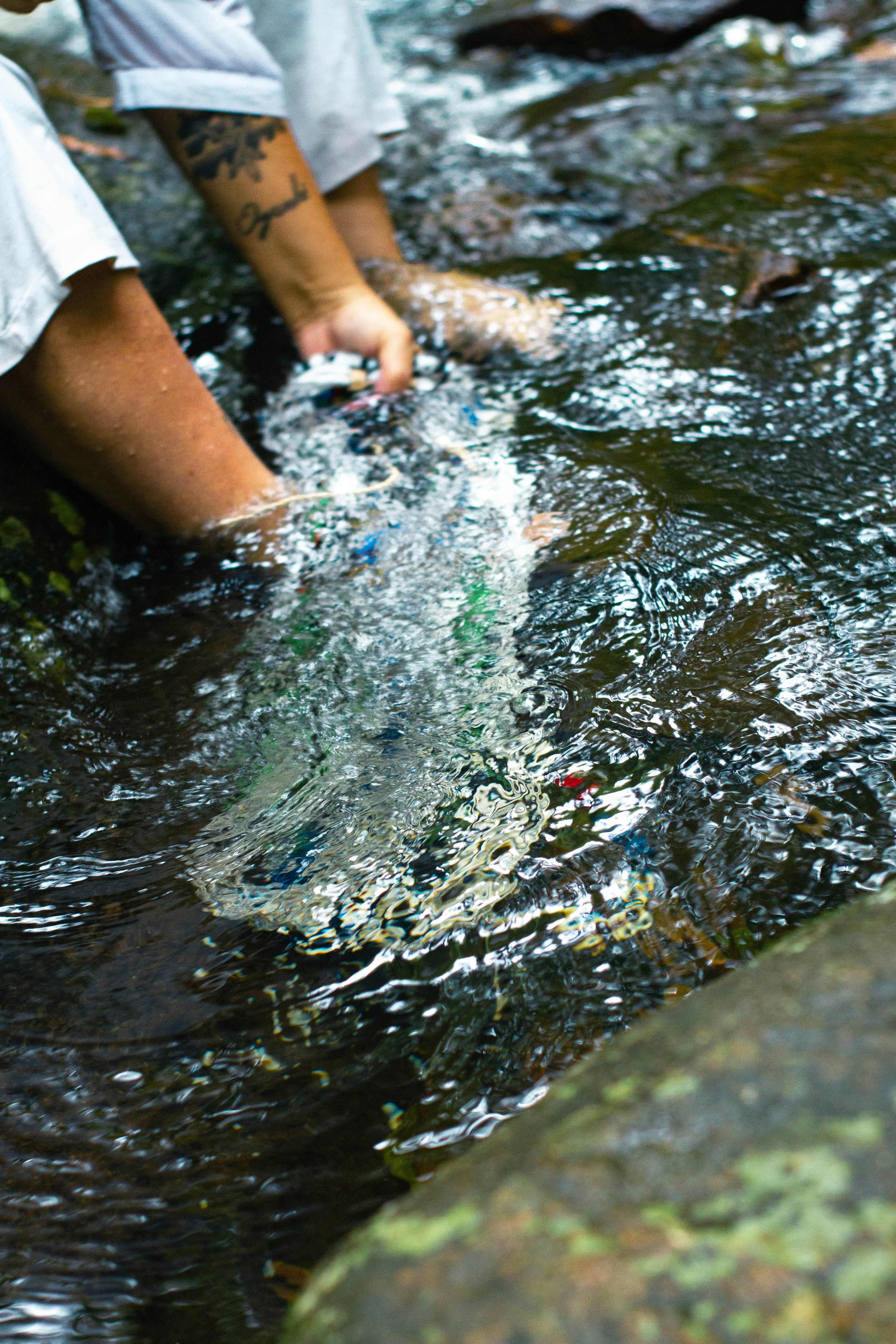 Una persona parada en un arroyo con una botella en la mano