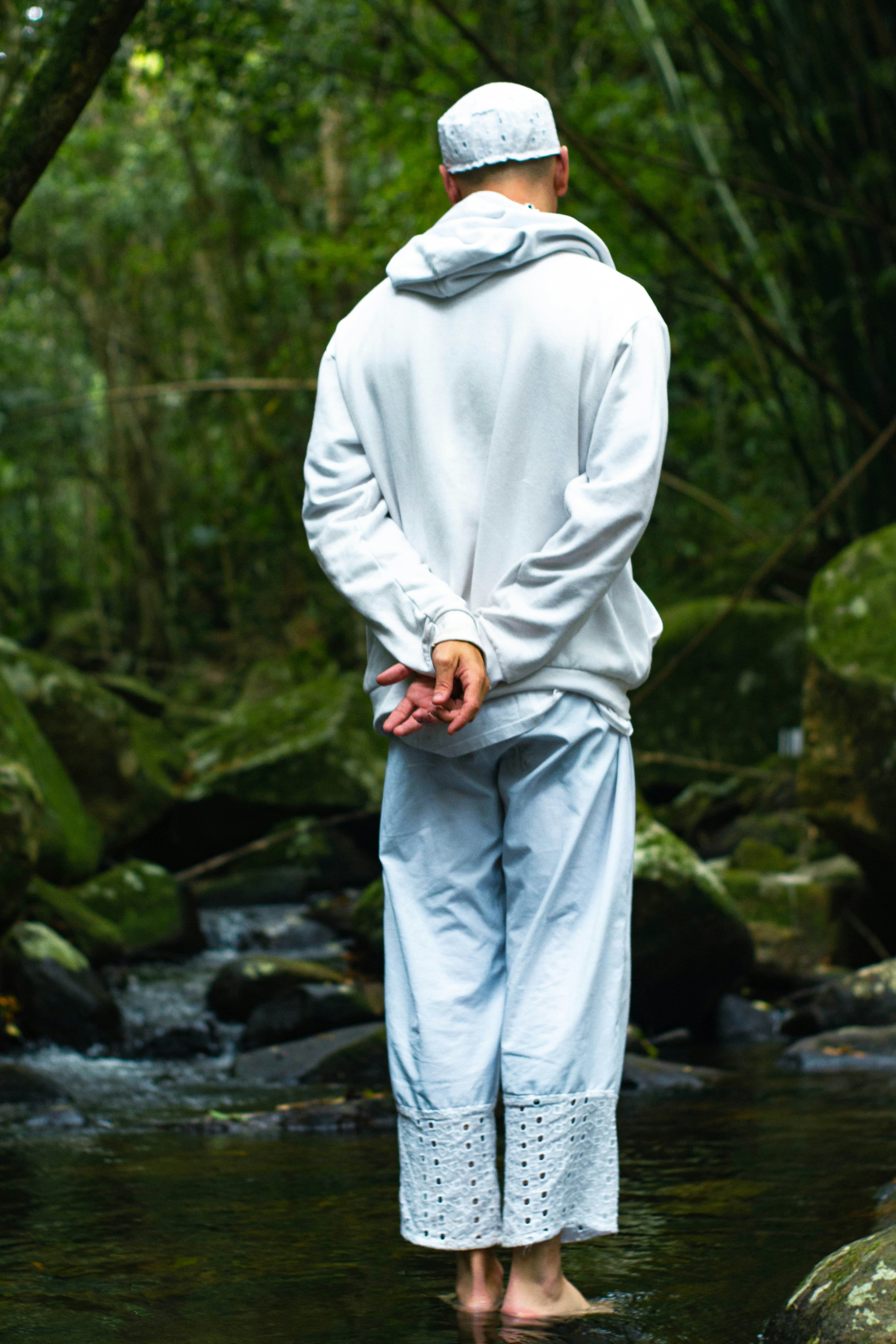 Un hombre de pie en un arroyo en medio de un bosque